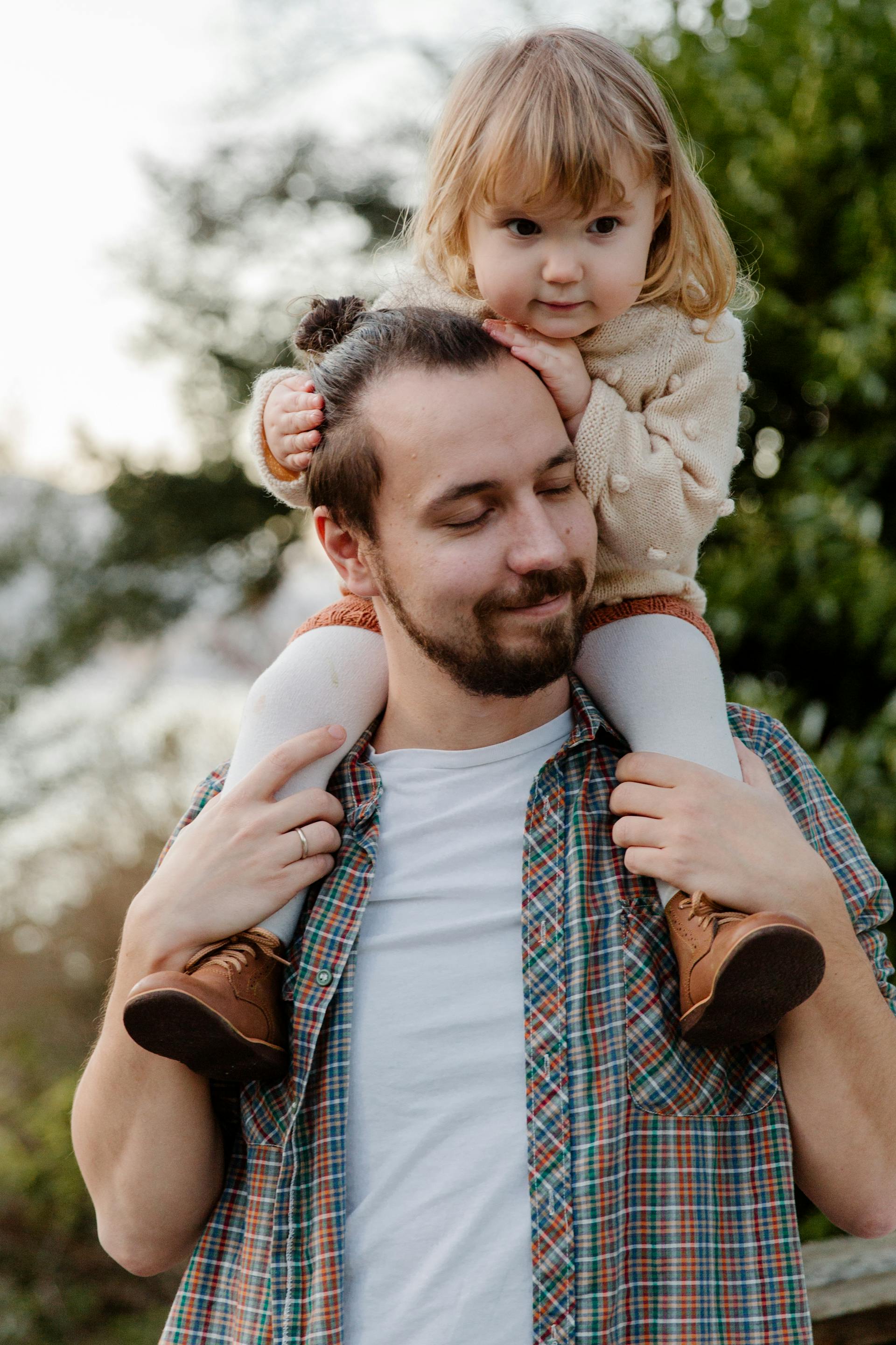 A father carrying his daughter | Source: Pexels