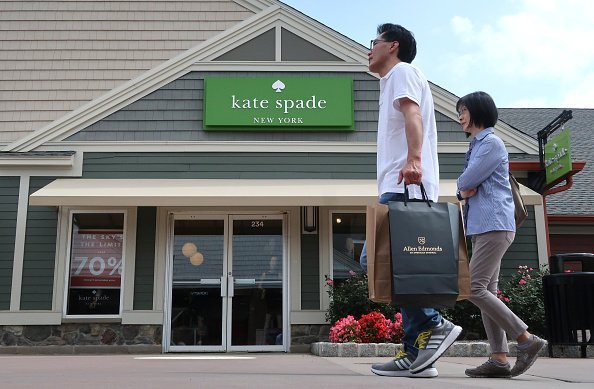  A man carries a bag as he walks past the kate spade store | Photo: Getty Images