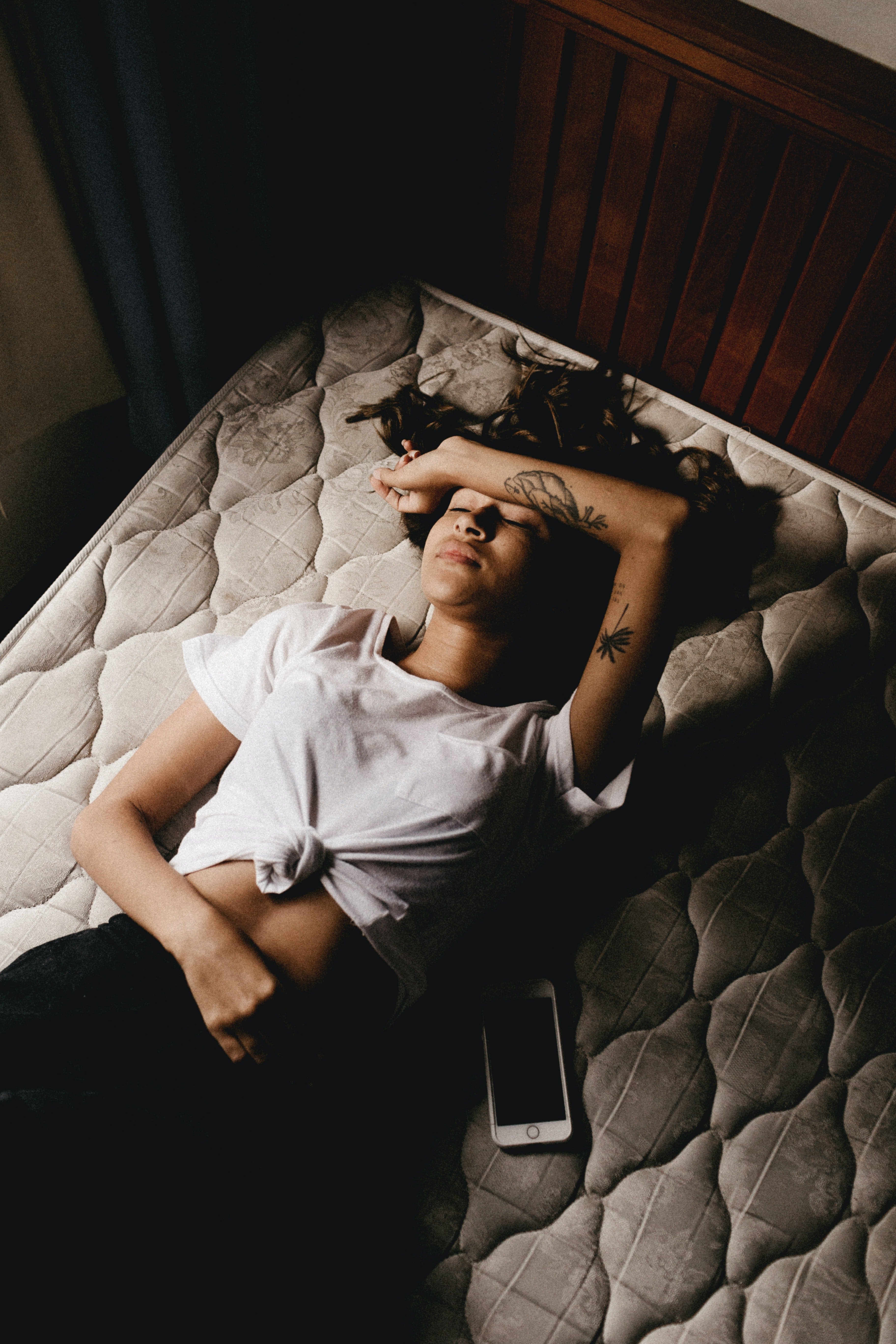 Una joven descansa sobre un colchón sin sábanas. | Foto: Pexels