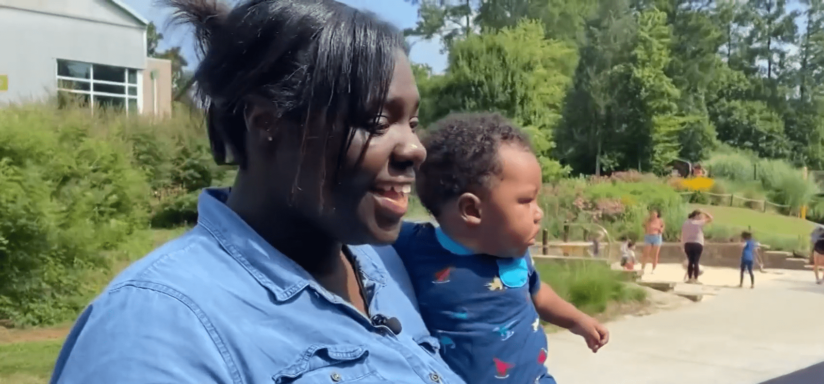 Charneseya Moye laughing while holding her son.│Source: Spectrum News 1 North Carolina