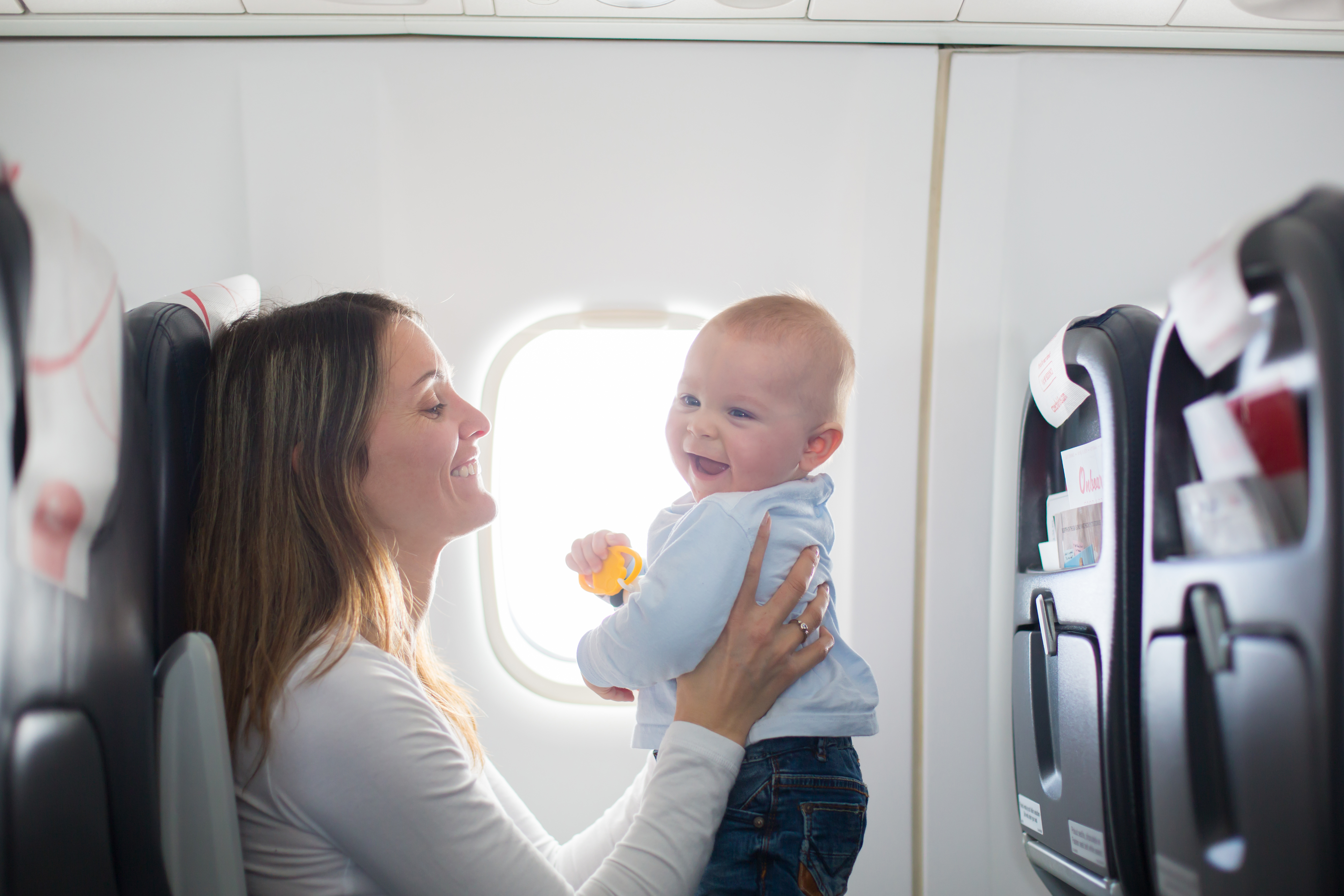 A woman holding a baby in an airplane | Source: Shutterstock