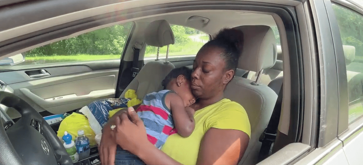Angela Thrower carrying her daughter inside the car during an interview with WRIC. | Source: WRIC