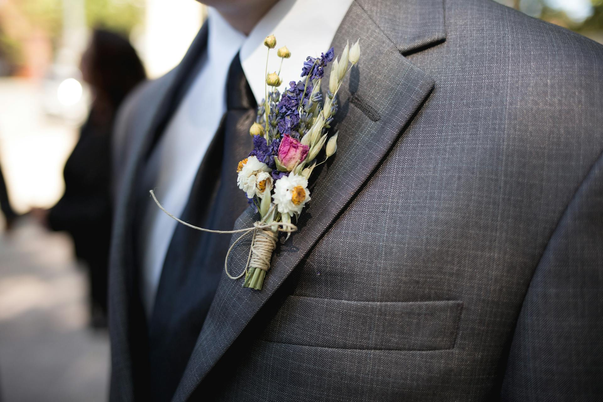 A flower boutonnière on a groom's gray suit jacket | Source: Pexels