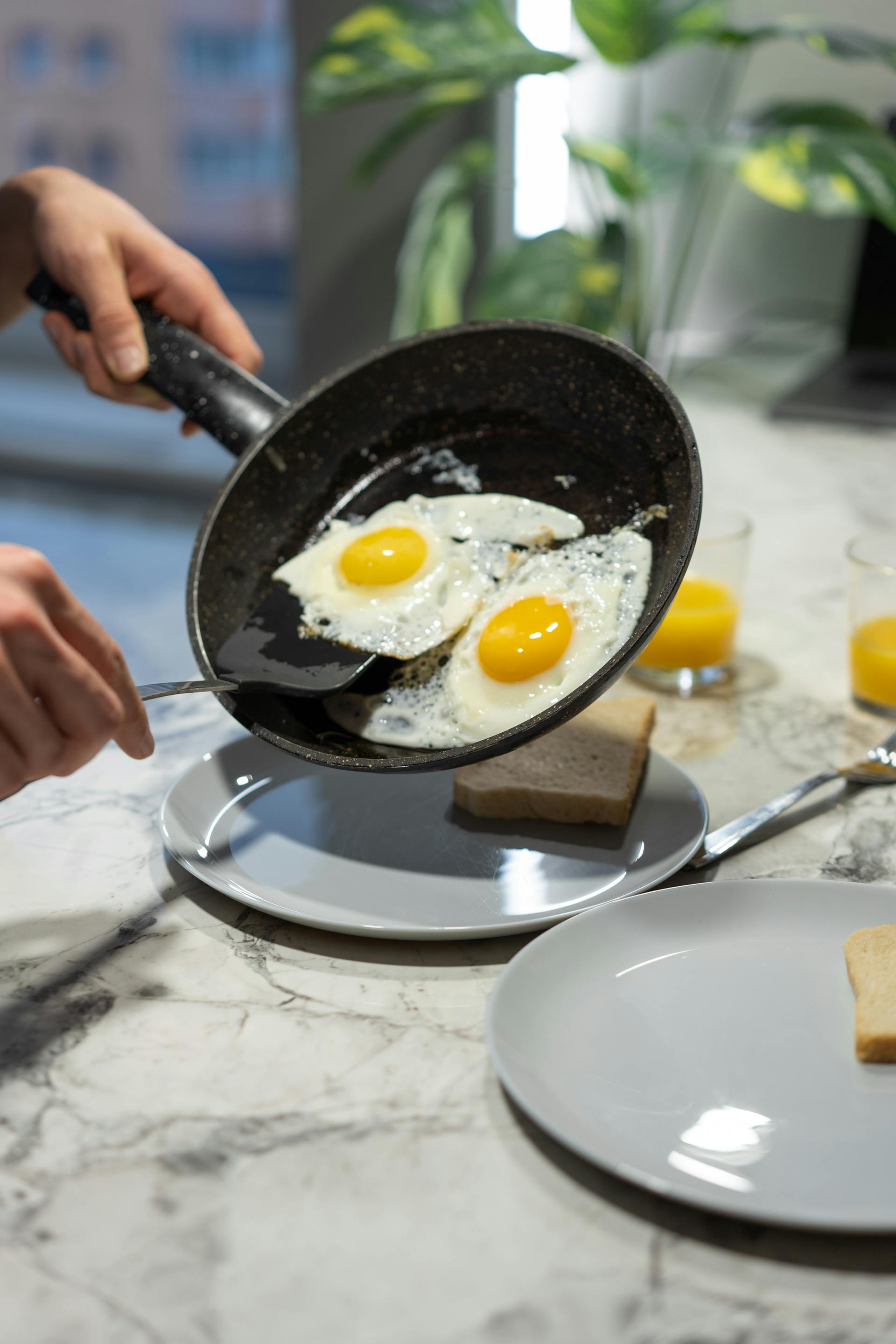 A person holding a frying pan with cooked eggs | Source: Pexels