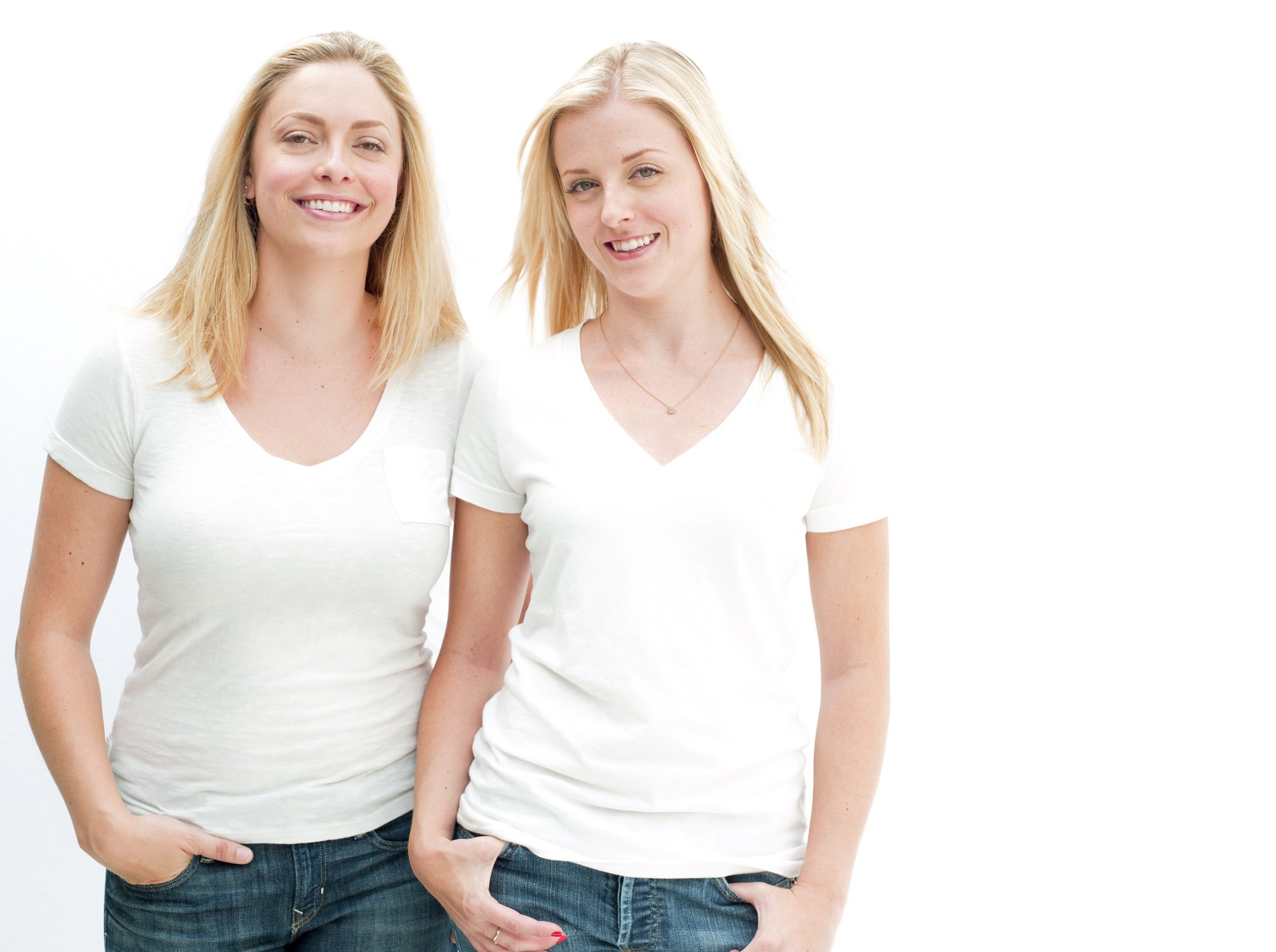 Portrait of two blondes in white T-shirts smiling. | Photo: Getty Images