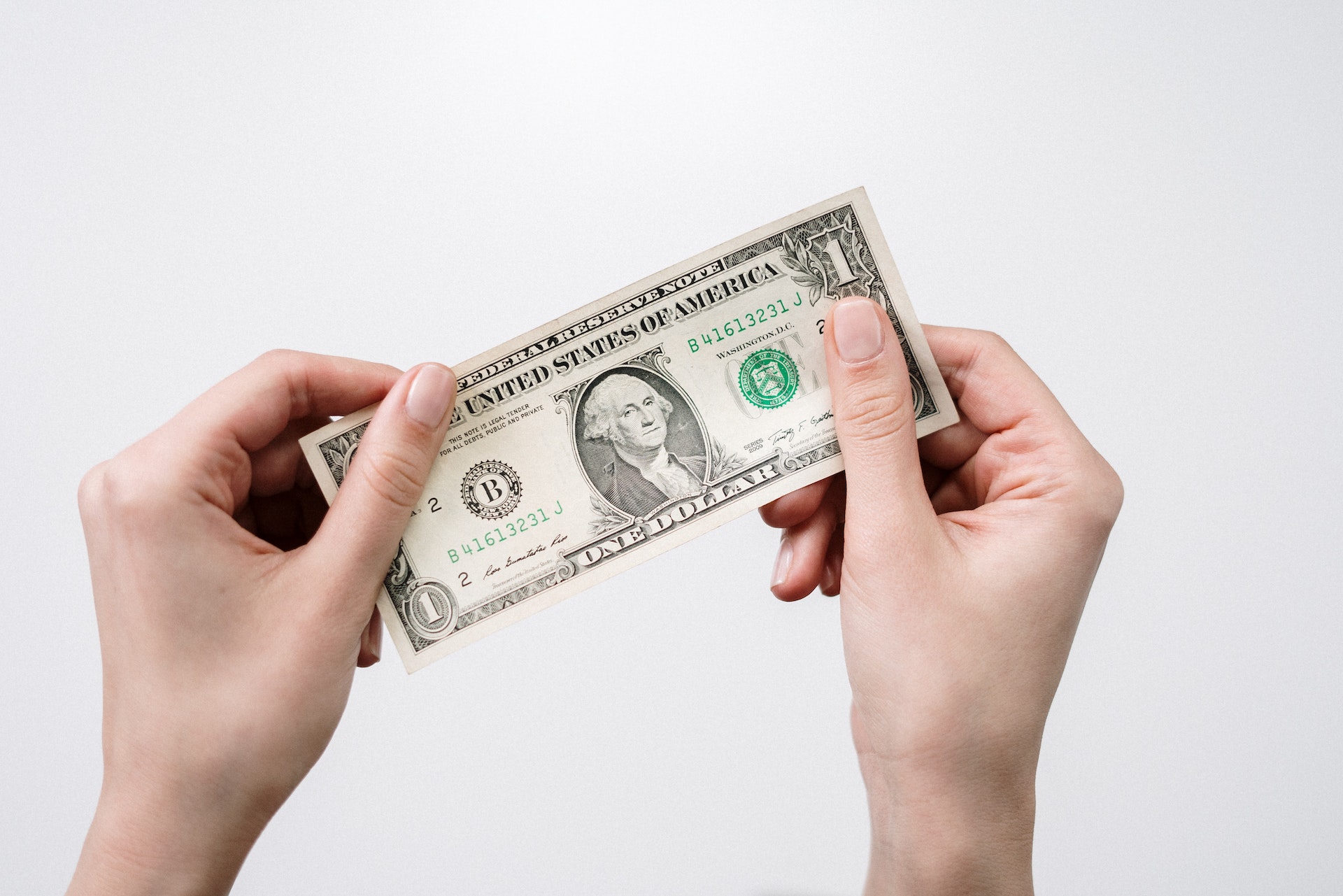A person holding a one-dollar bill | Source: Pexels