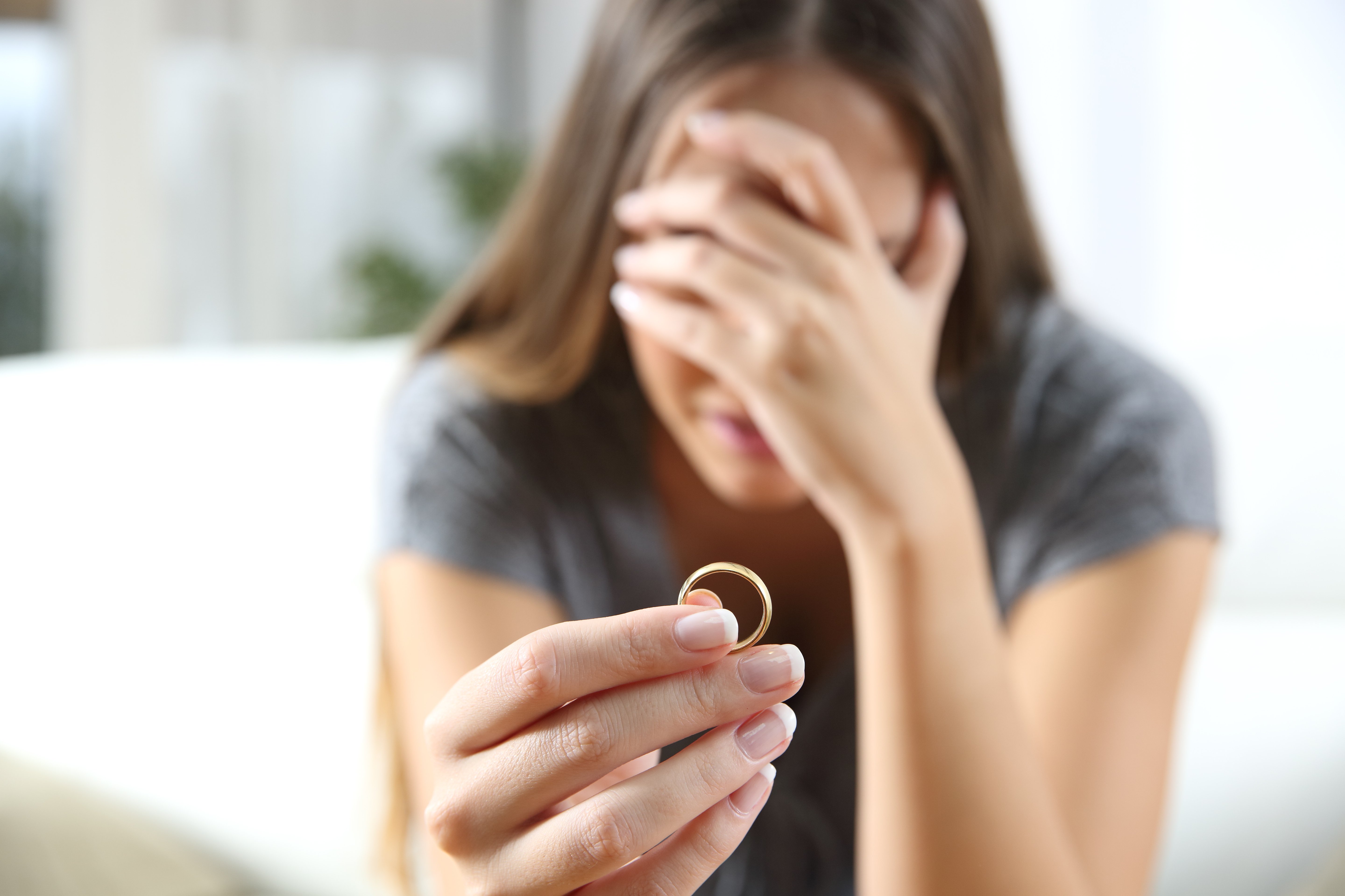 Mujer con anillo en la mano, llorando. | Foto: Shutterstock