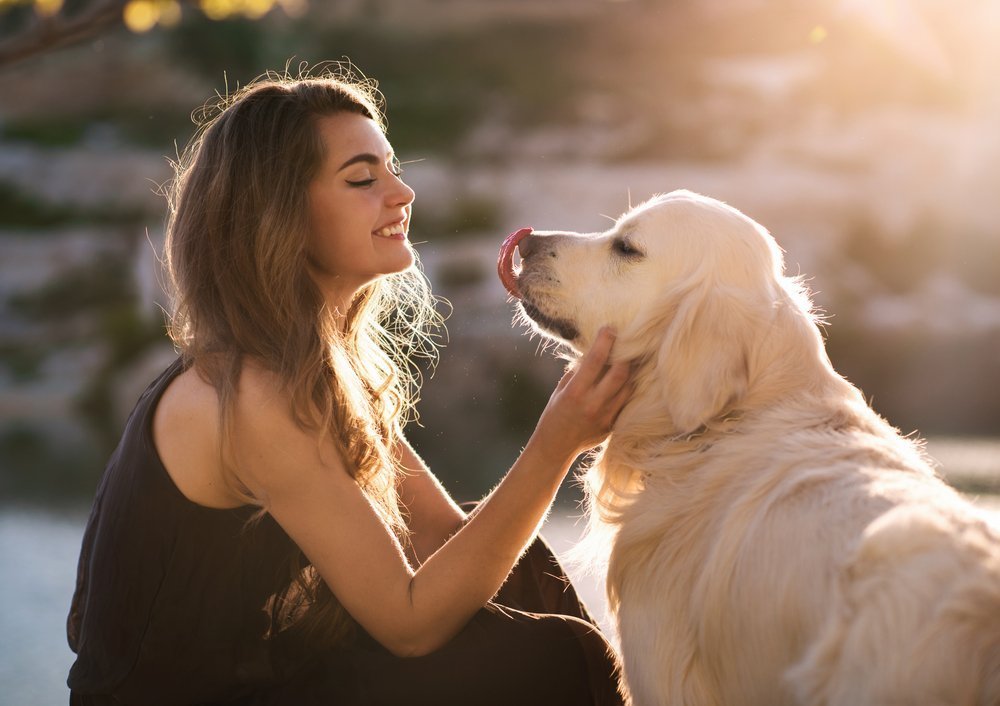 Una mujer con su perro jugando al aire libre. | Foto: Shutterstock