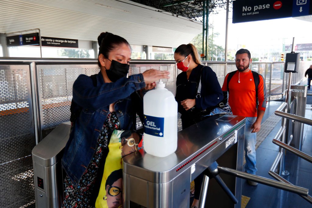 Pasajeros se aplican desinfectante antes de ingresar a la estación de tren para prevenir la infección por COVID-19, el 27 de marzo de 2020 en Guadalajara, México. | Foto por Refugio Ruiz vía Getty Images