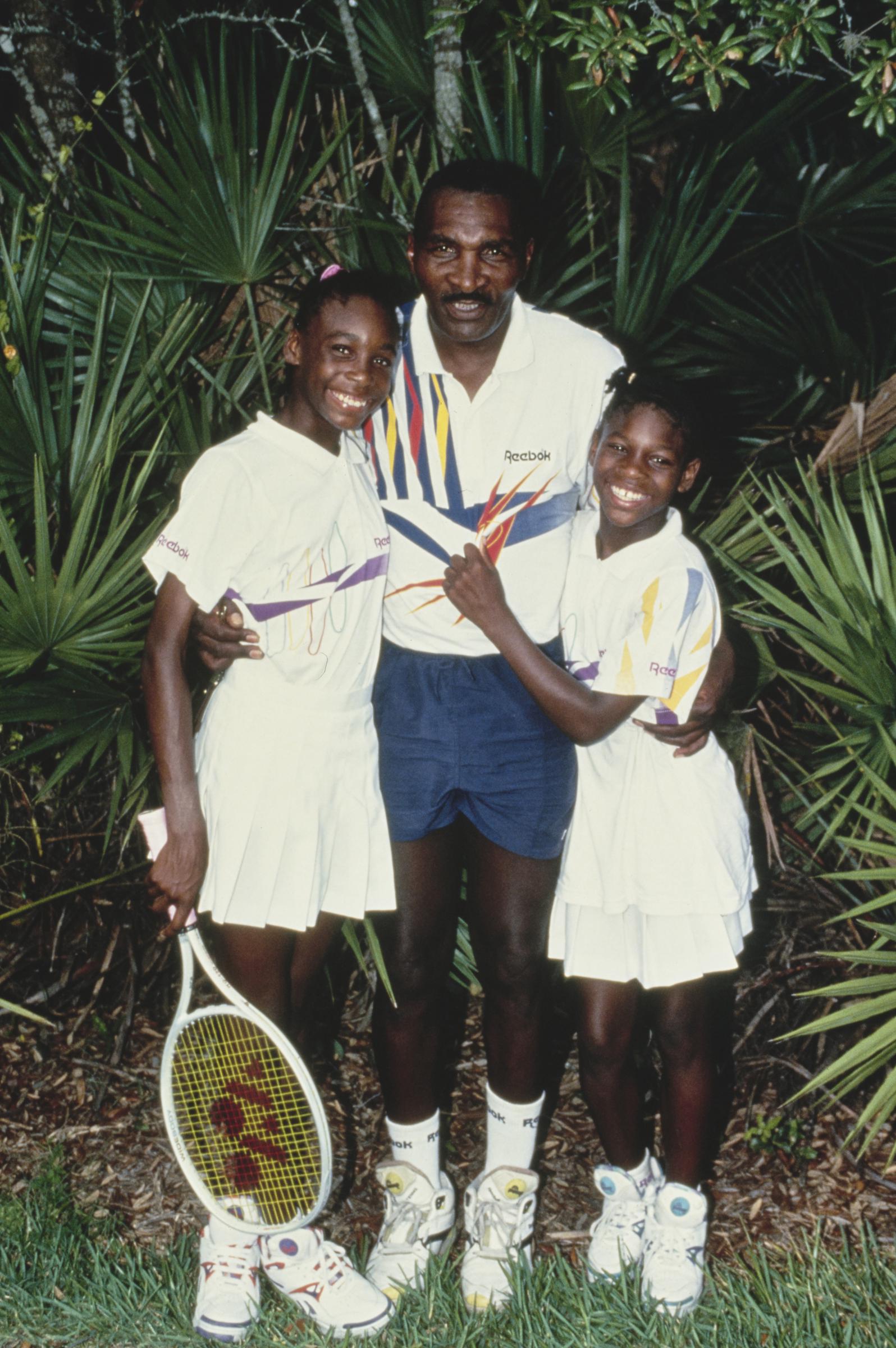 Venus and Serena pose with their father, Richard Williams, during a training session on July 22, 1992 | Source: Getty Images