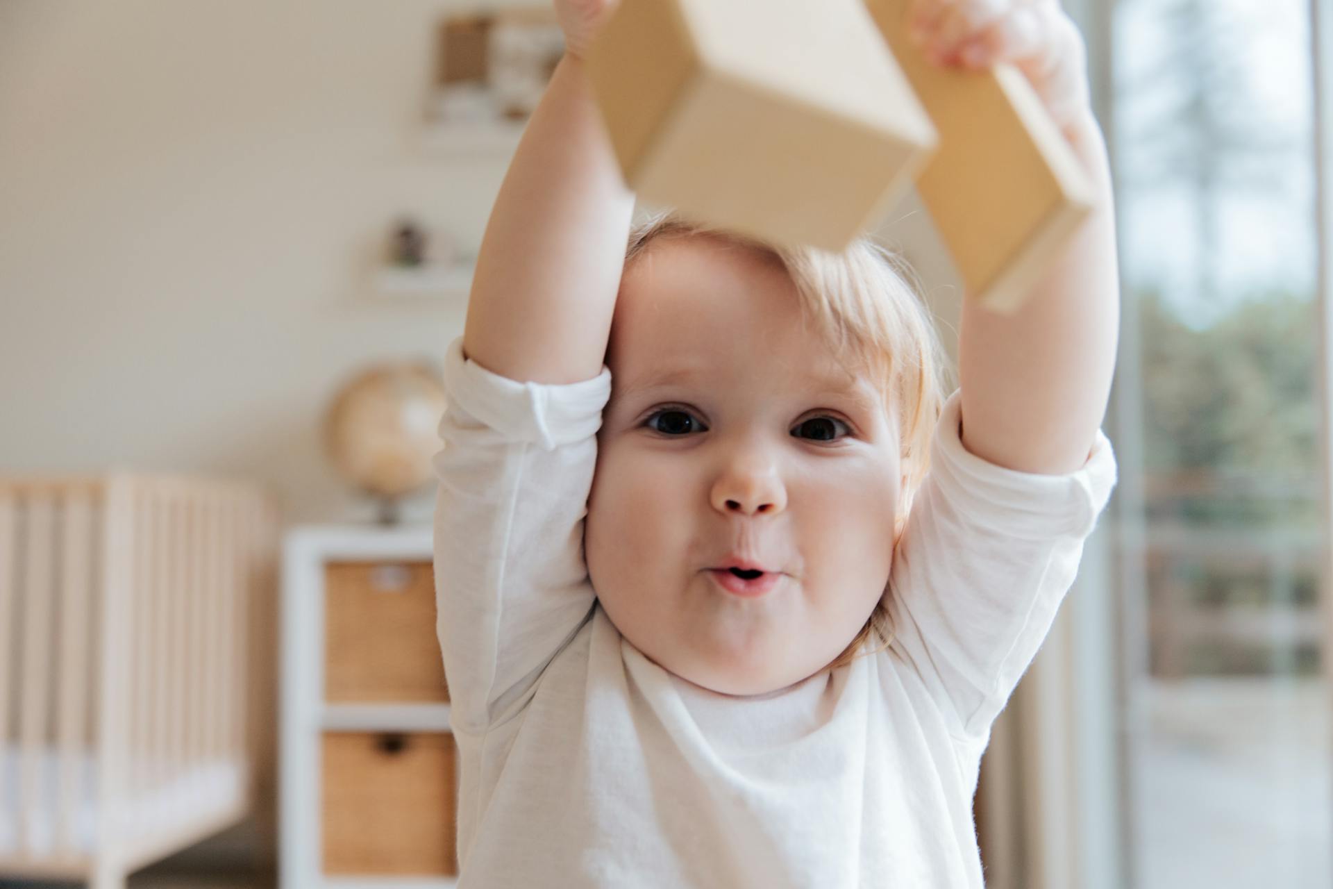 A little boy holding a wooden block | Source: Pexels