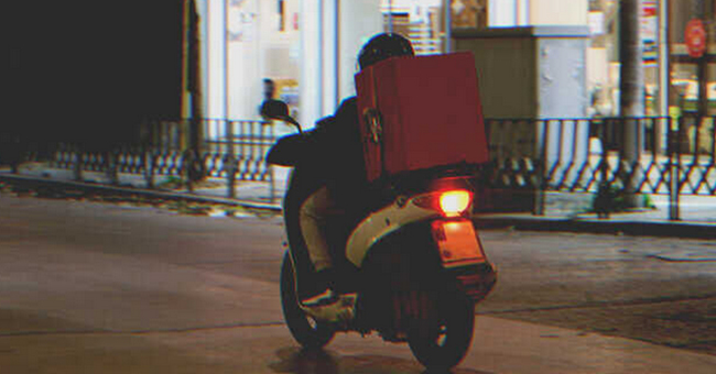 Delivery man on scooter. | Source: Shutterstock