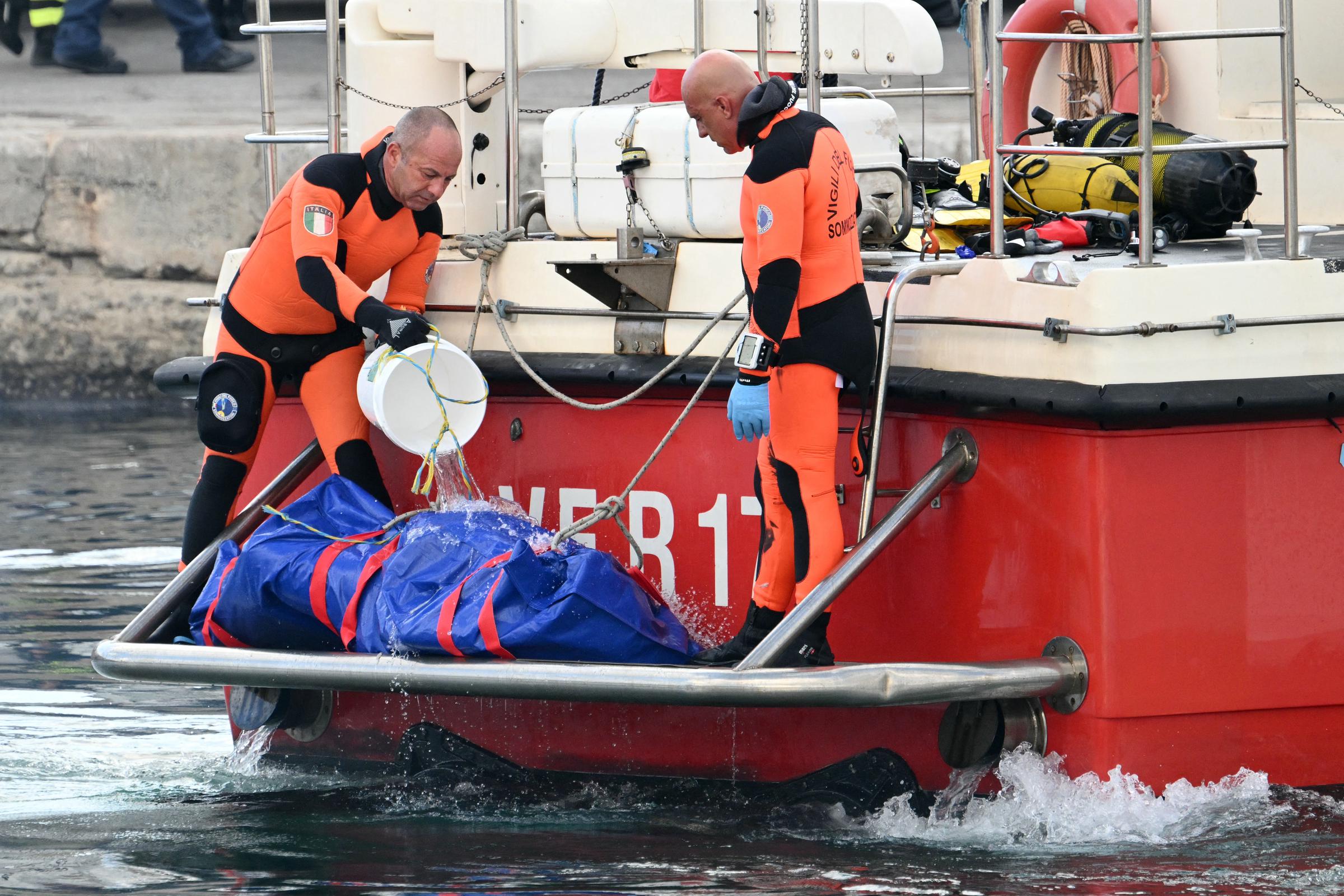 Rescuers carry a body after divers return in Porticello harbor near Palermo, on August 22, 2024, three days after the British-flagged luxury yacht Bayesian sank. | Source: Getty Images