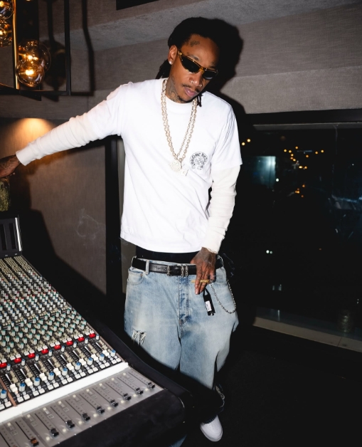 Wiz Khalifa poses in a recording studio wearing a long-sleeve shirt, jeans, and sunglasses in a post dated April 30, 2025. | Source: Facebook/Wiz Khalifa