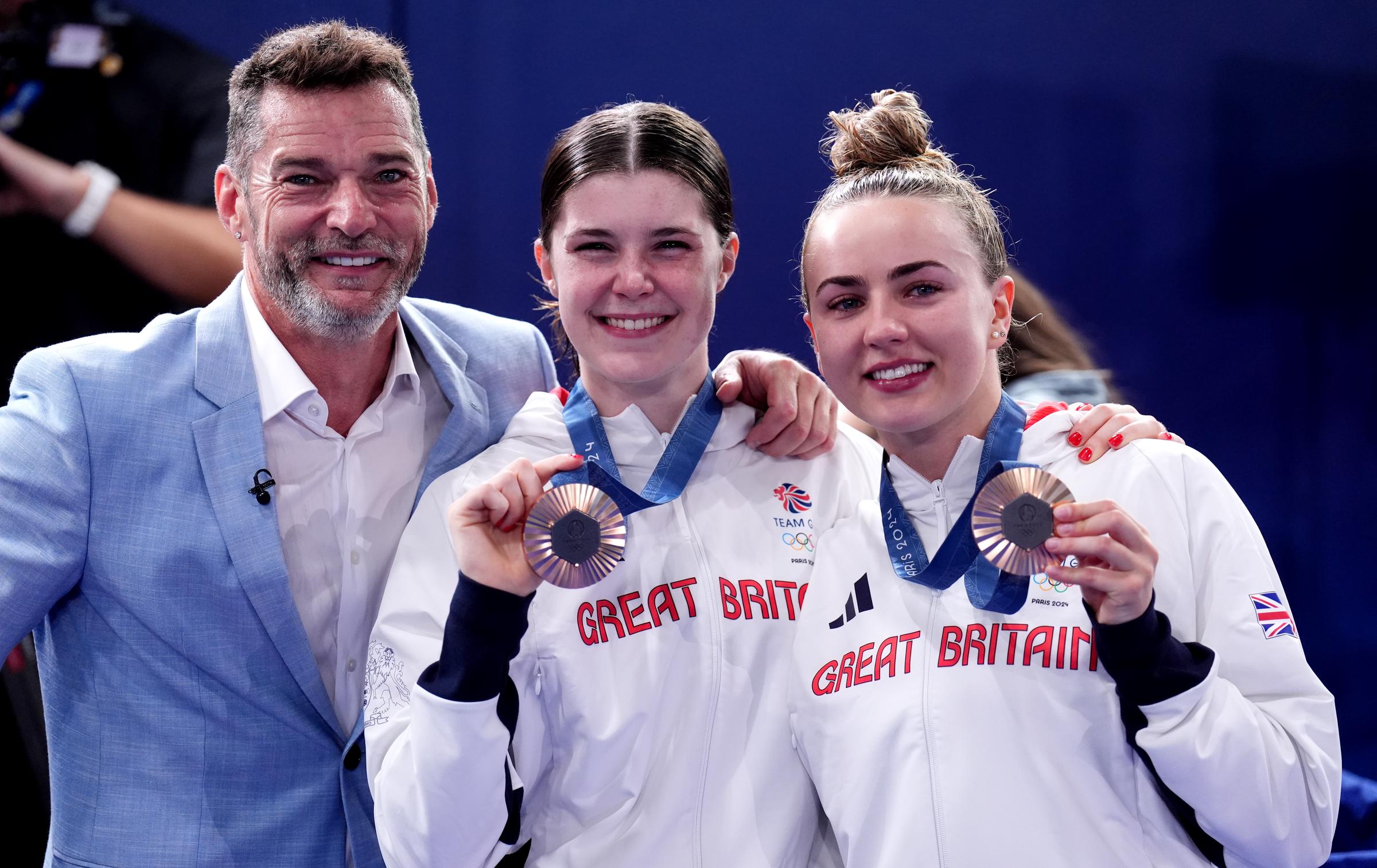 Fred Sirieix with his daughter Andrea Spendolini-Sirieix and her diving partner Lois Toulson following the Women's Synchronised 10m Platform Final at the Aquatics Centre on the fifth day of the 2024 Paris Olympic Games on 31 July in France. | Source: Getty Images