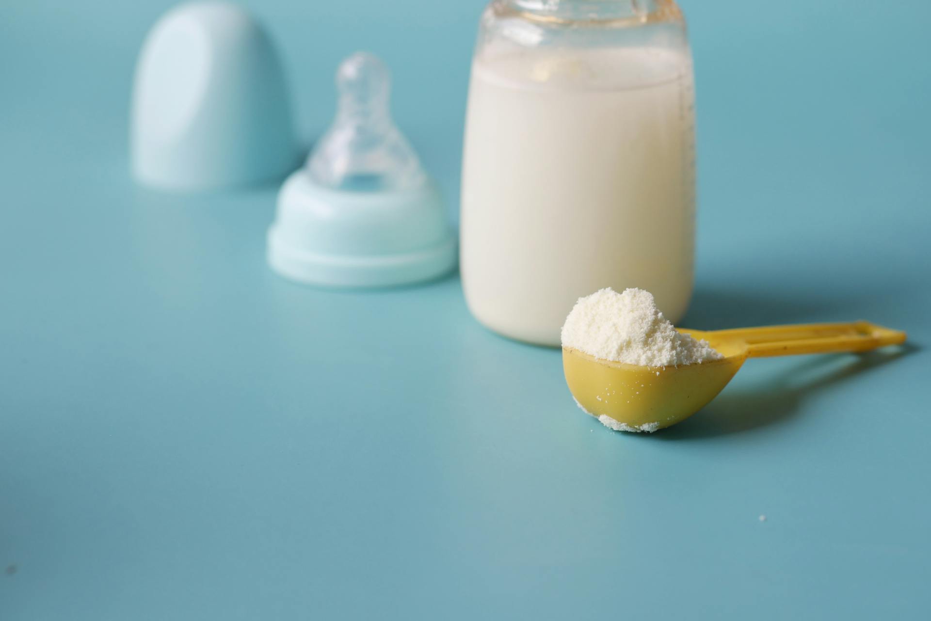Close-up shot of a scooped formula milk powder lying next to a feeding bottle | Source: Pexels
