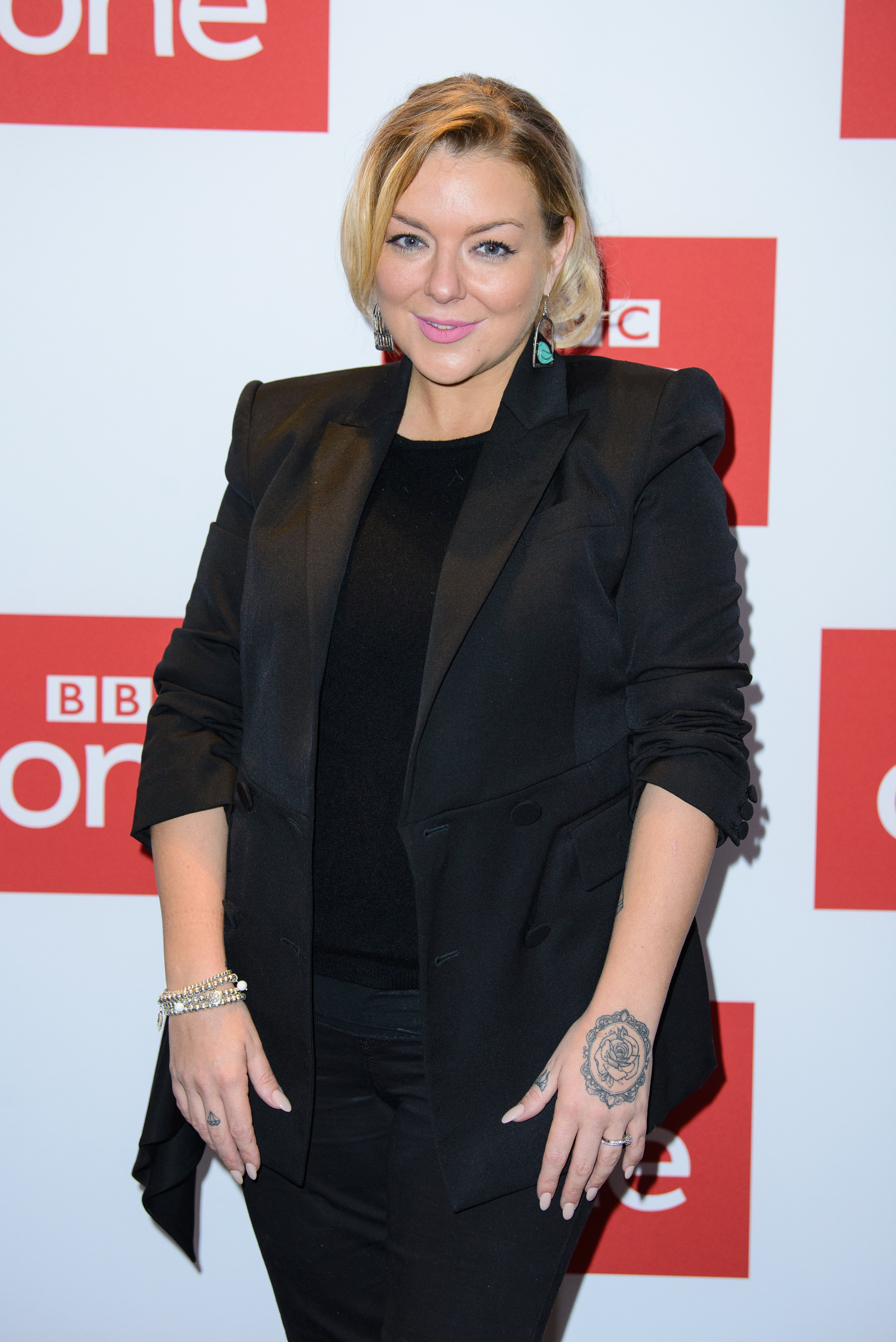 Dressed in an all-black ensemble with a satin-lapelled blazer, Smith poses at BAFTA in London on 27 November 2018 for the launch of the BBC One drama "Care", wearing her hair in a short, sleek blonde bob.