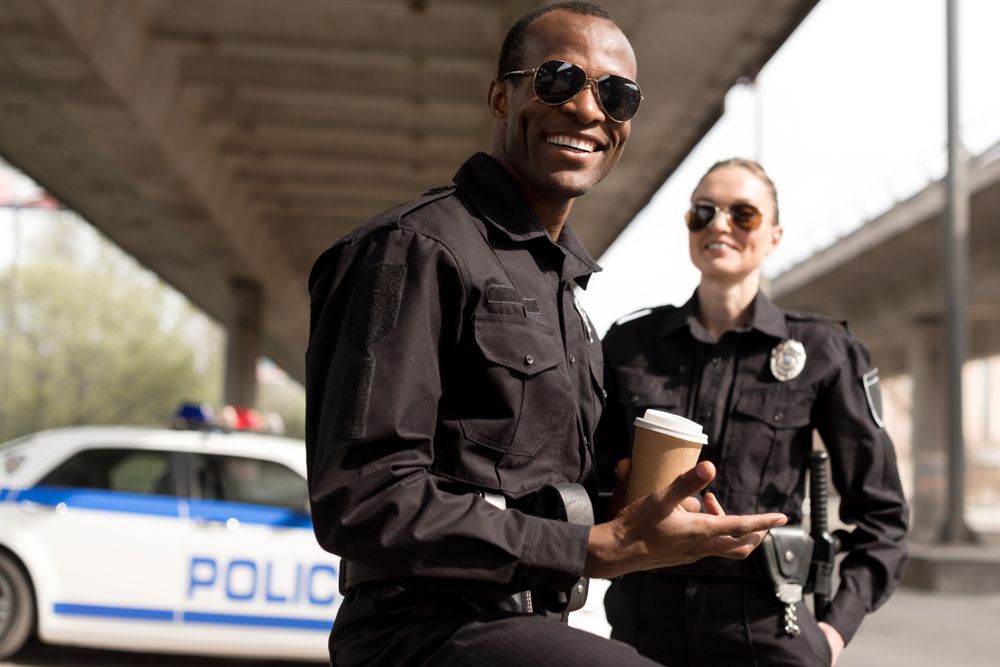 Polizisten lächeln während einer Kaffeepause. | Quelle: Shutterstock