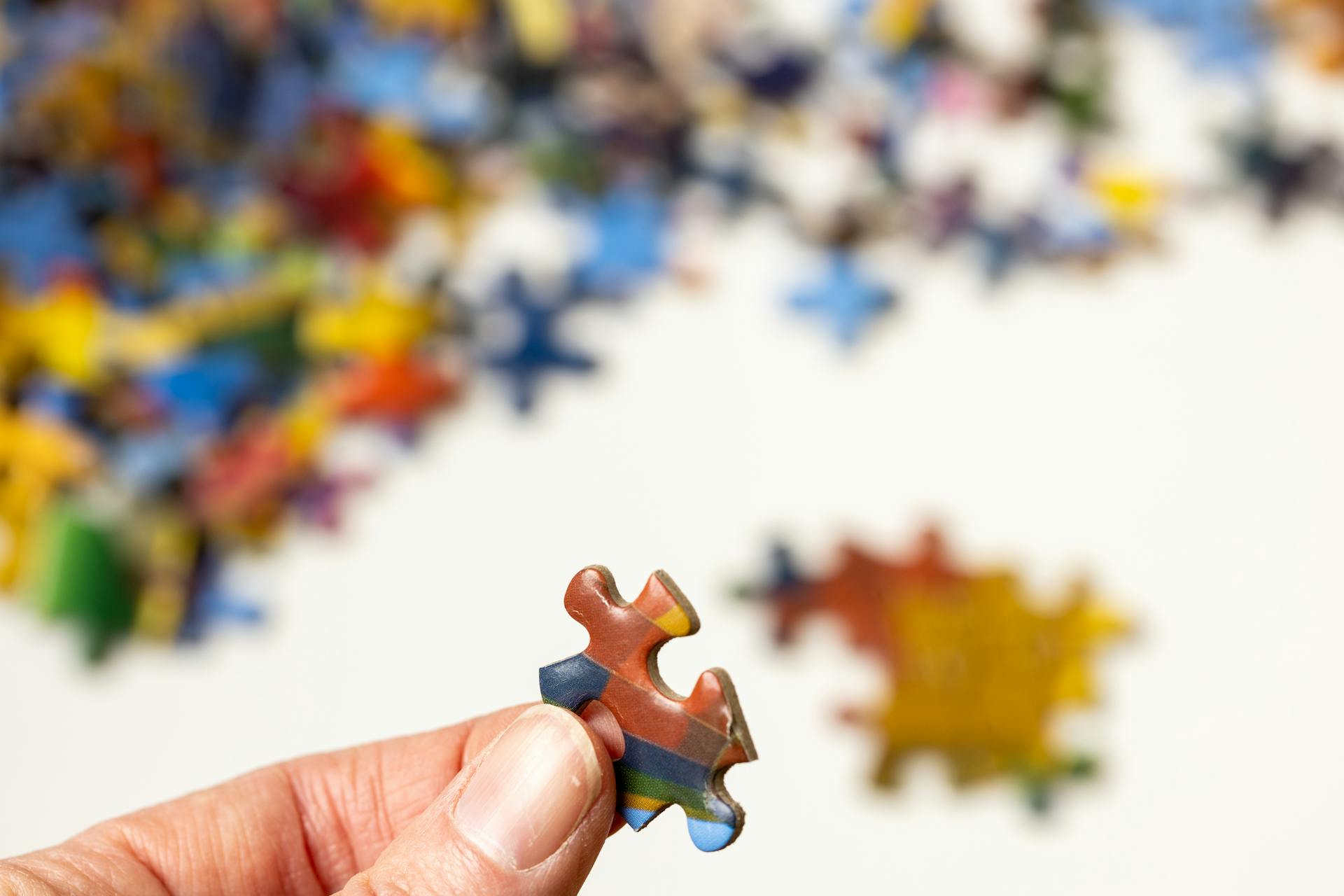 A closeup of a person holding a jigsaw puzzle piece | Source: Pexels