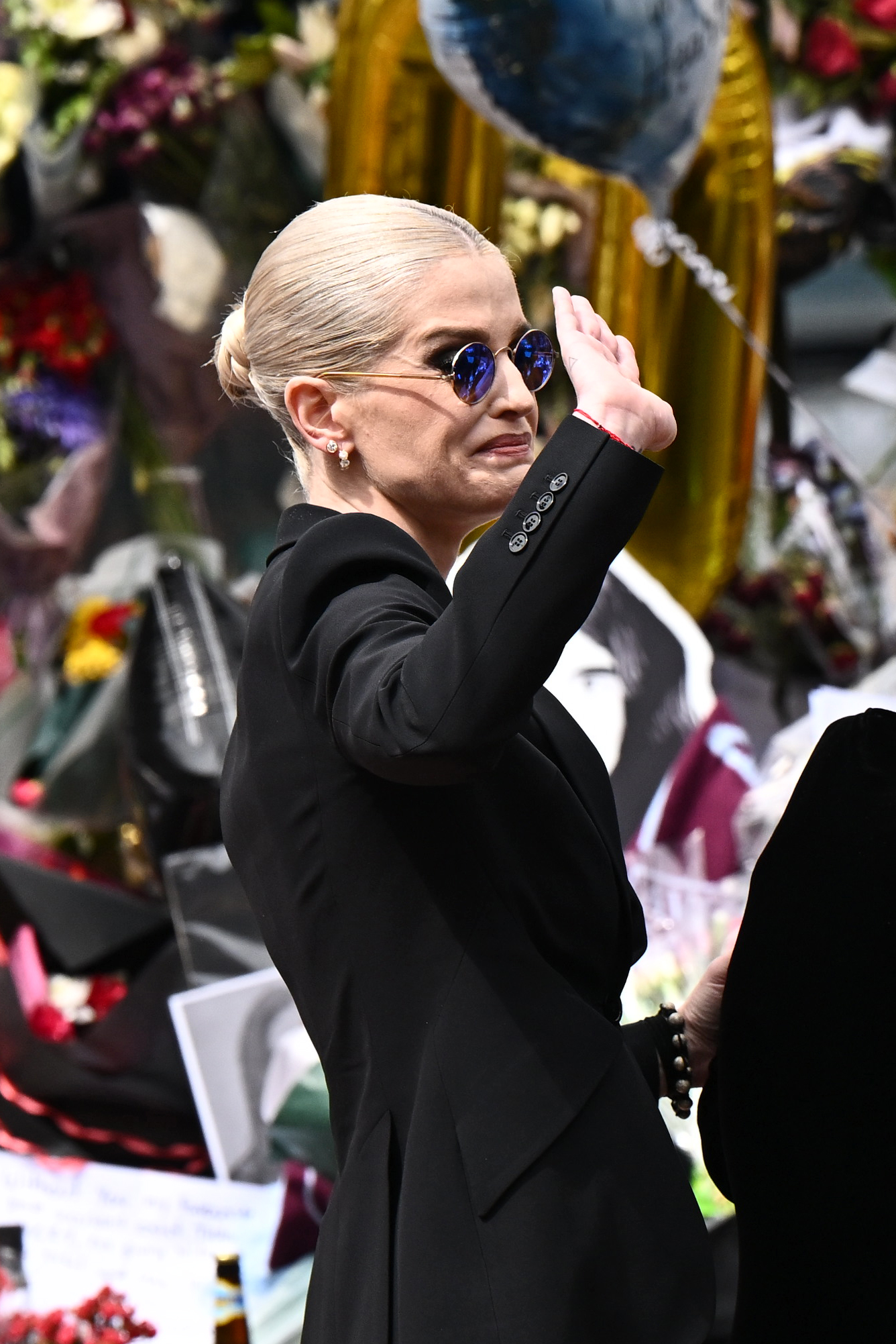 Kelly Osbourne greets fans as she arrives to view tributes to the late Ozzy Osbourne as his funeral cortege travels through his home city of Birmingham on July 30, 2025 in England. | Source: Getty Images