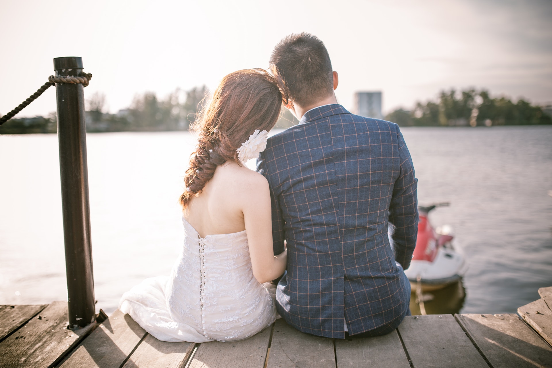 Bride and groom sitting on a dock | Source: Pexels