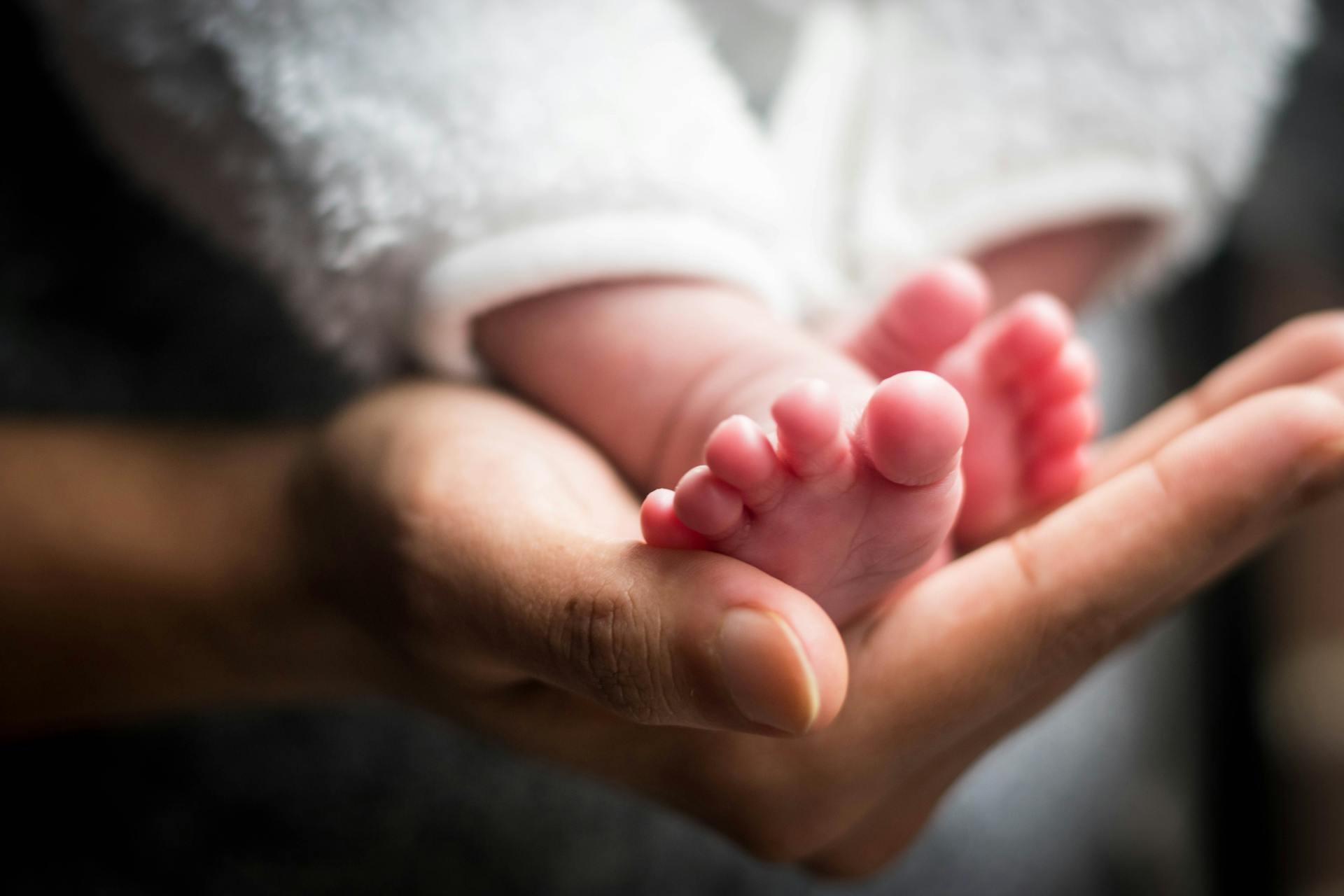 A person holding a baby's feet | Source: Pexels