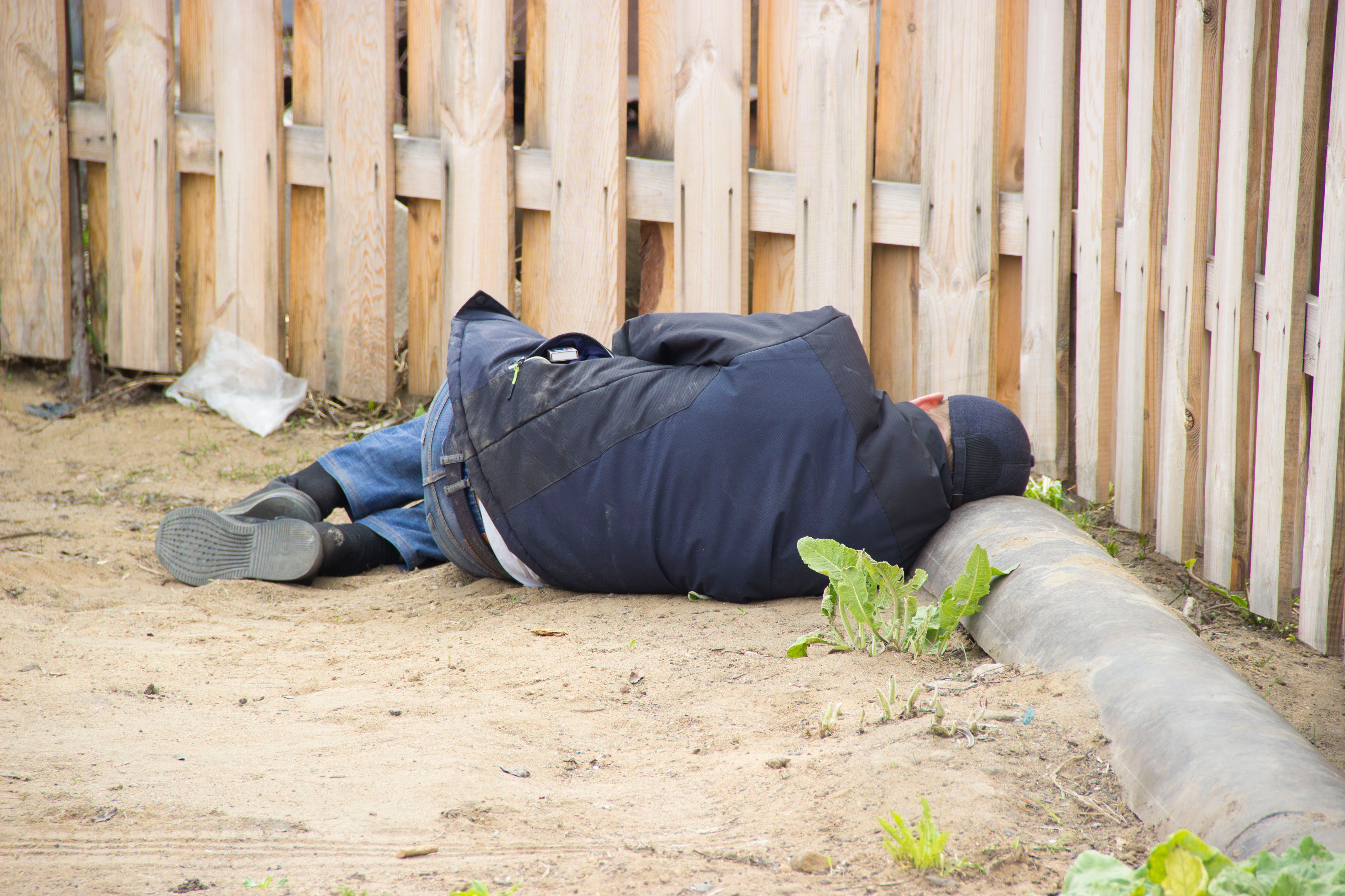 Man laying by the fence | Shutterstock
