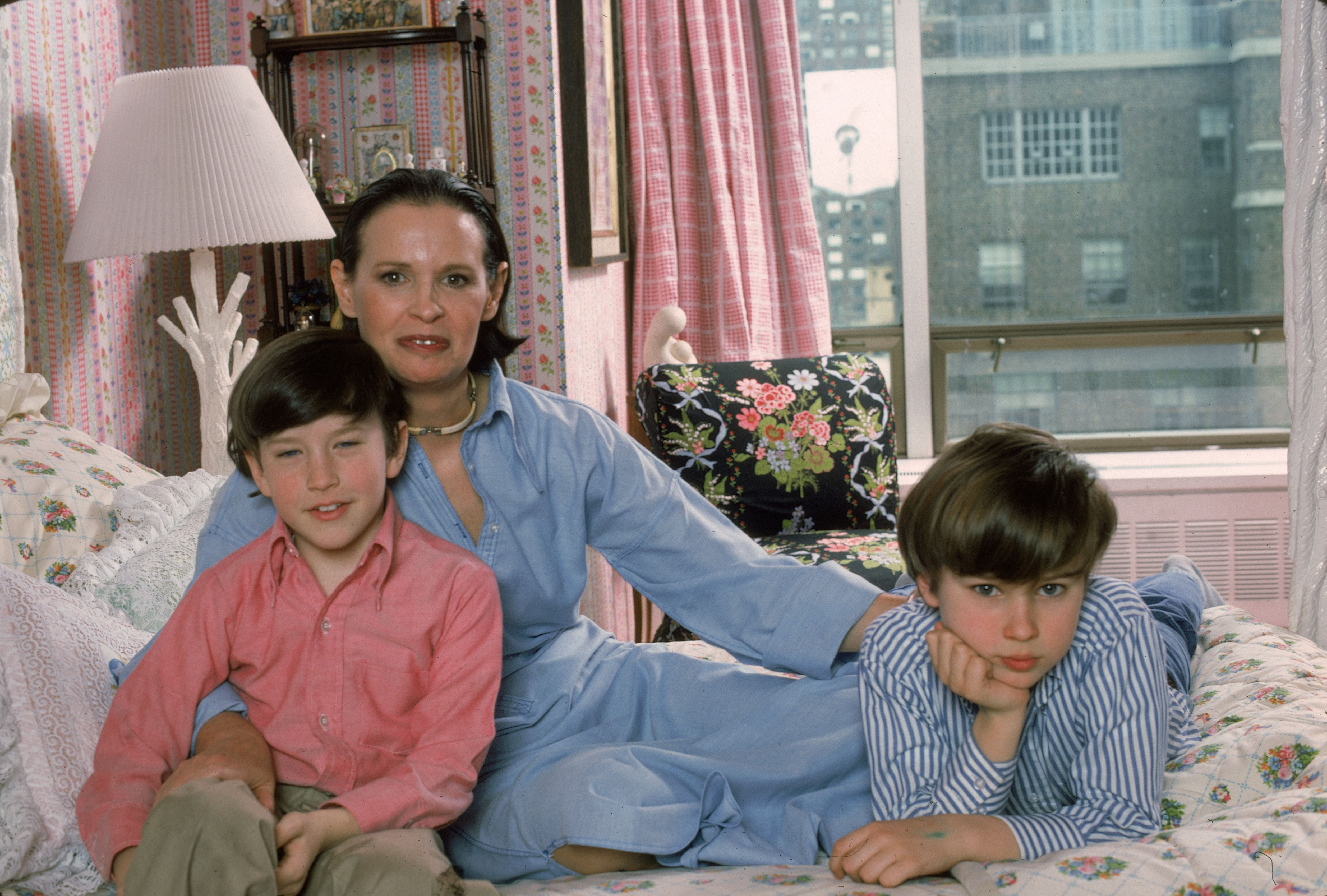 Anderson Cooper and Carter Vanderbilt Cooper with their mother Gloria Vanderbilt on Gloria's bed in their NY apartment, 1976 | Photo: Getty Images 