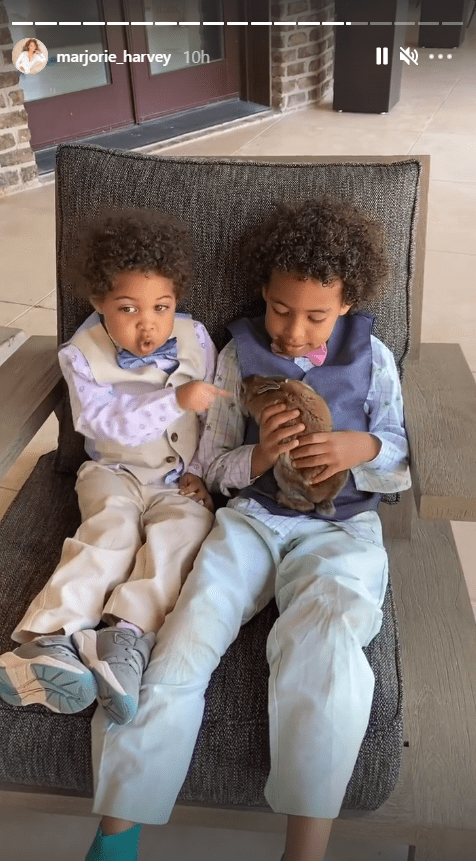 Two of Marjorie and Steve Harvey’s grandchildren playing with a rabbit while sitting on a chair. | Source: Instagram/marjorie_harvey