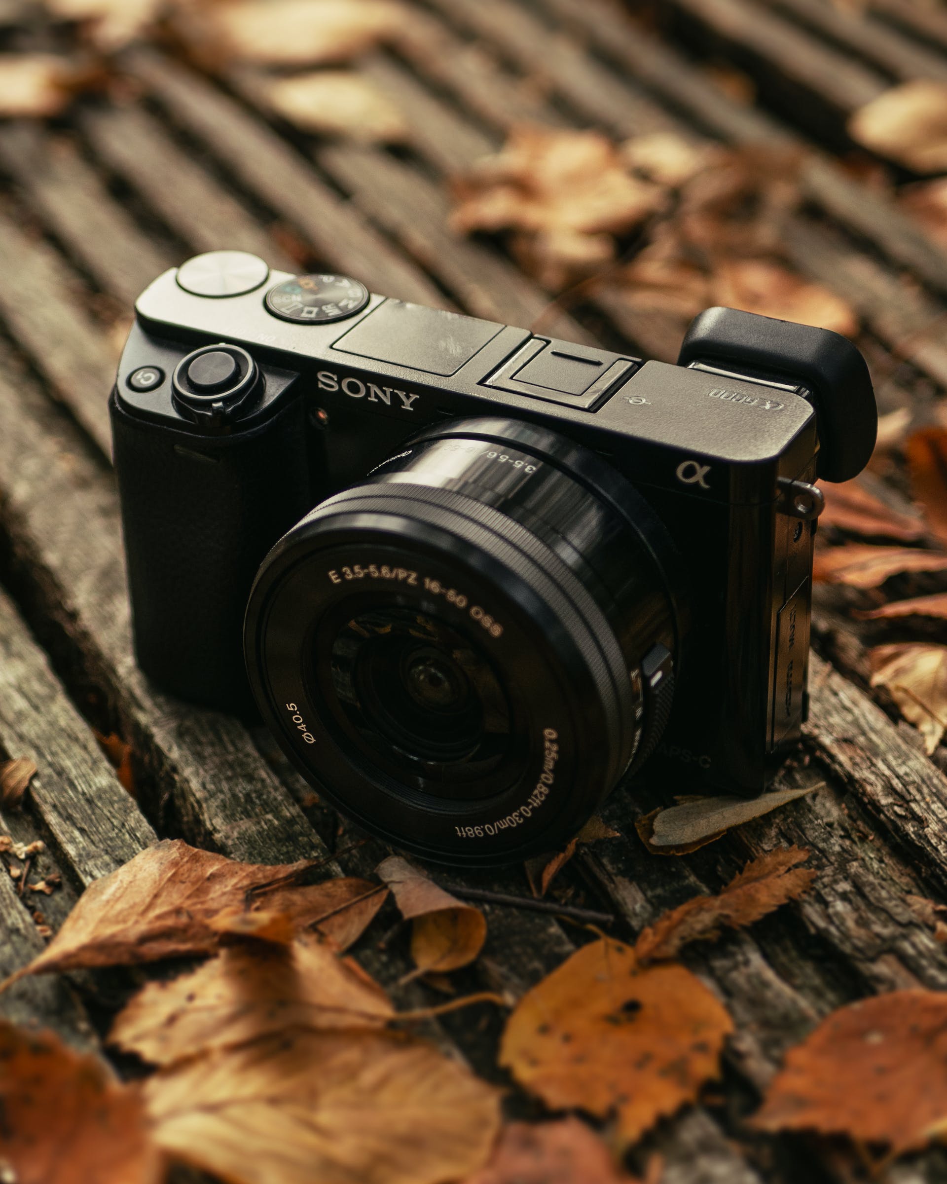 A digital camera lying on a wooden surface | Source: Pexels