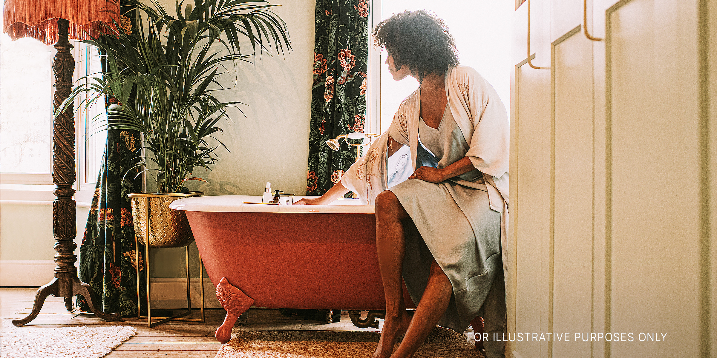 A woman perched on a bathtub | Source: Getty Images