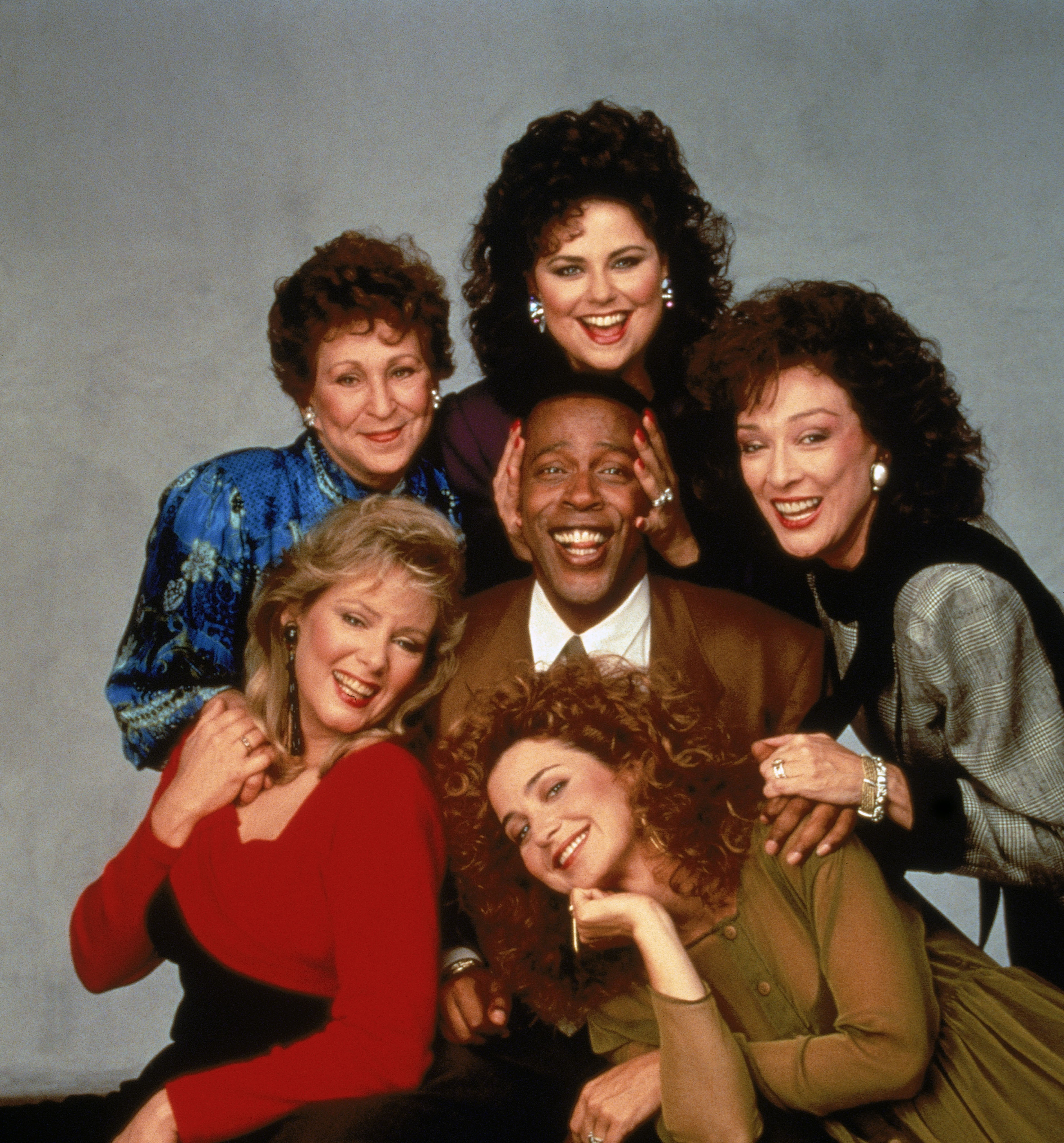 Clockwise from bottom left: Jean Smart, Alice Ghostley, Delta Burke, Dixie Carter, Annie Potts, and Meshach Taylor on the set of "Designing Women" in 1987 | Source:Getty Images