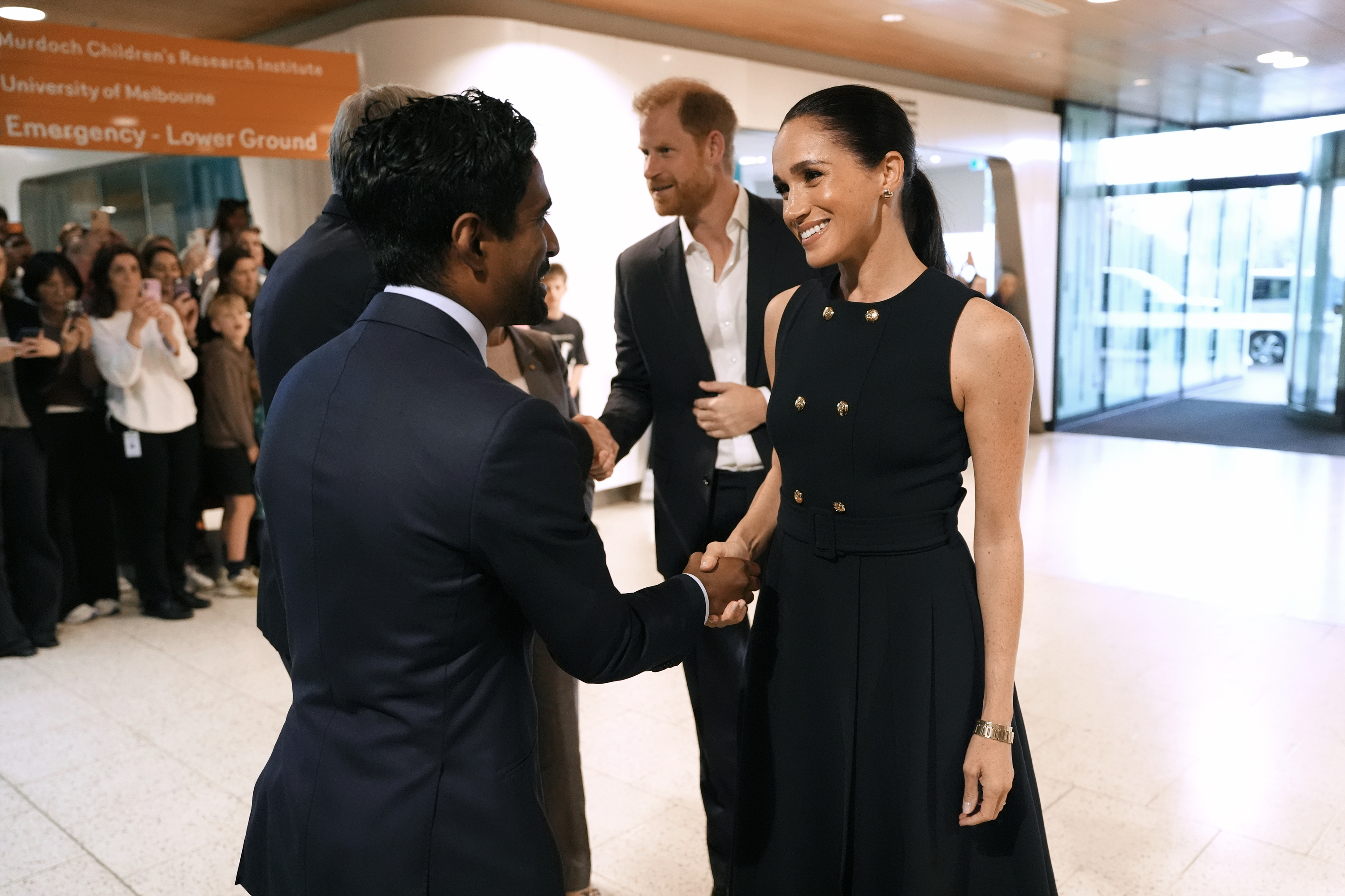 Meghan and Prince Harry gree Kog Ravindran, chief of staff to the CEO & executive director of communications at the Royal Children's Hospital, during a visit on April 14, 2026 in Melbourne, Australia. | Source: Getty Images