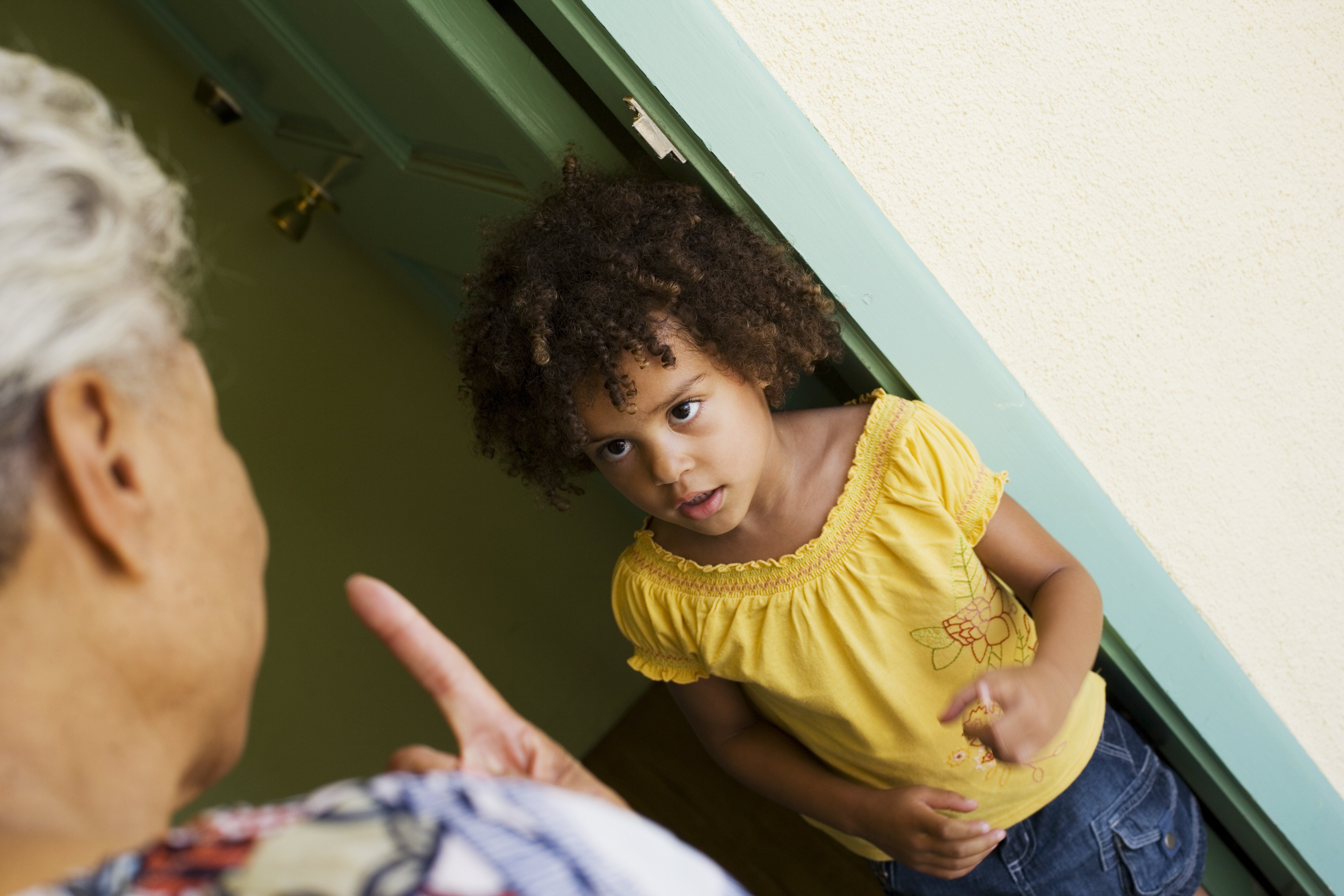 Woman scolding young girl in doorway | Photo: Getty Images