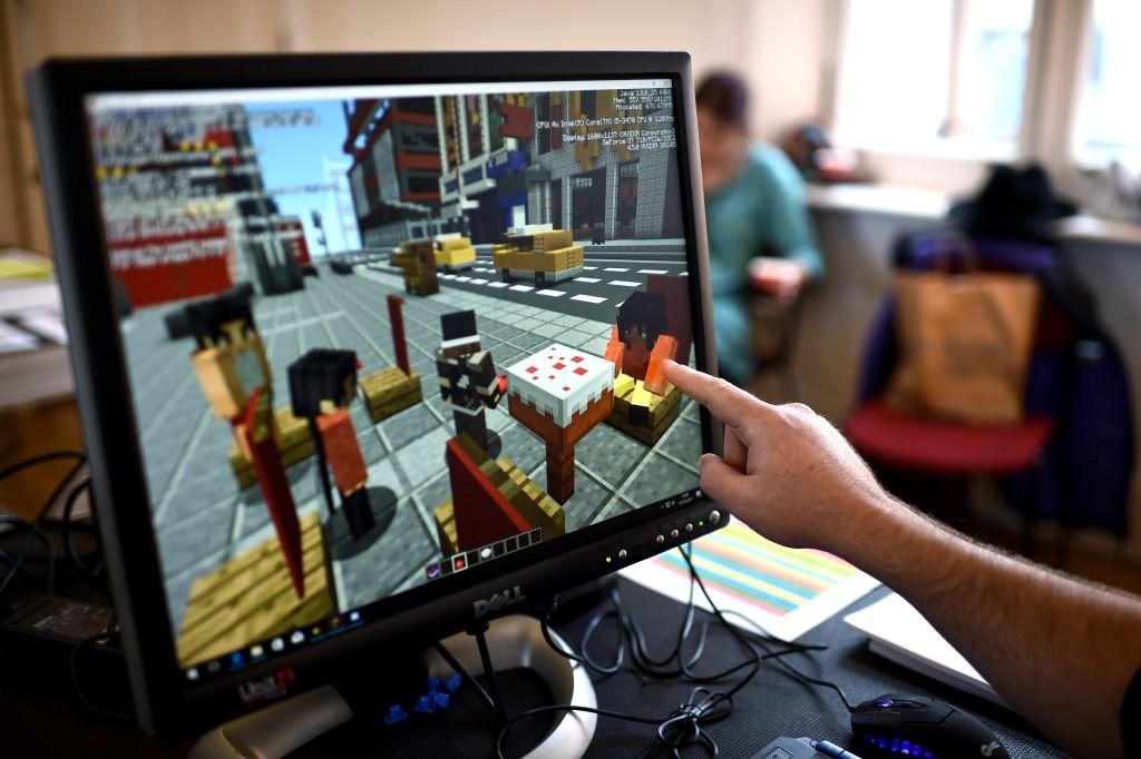 A Minecraft digital artist points at the digital version of the character 'Sal' as they work backstage during a 'Playcraft' live rehearsal. | Source: Getty Images