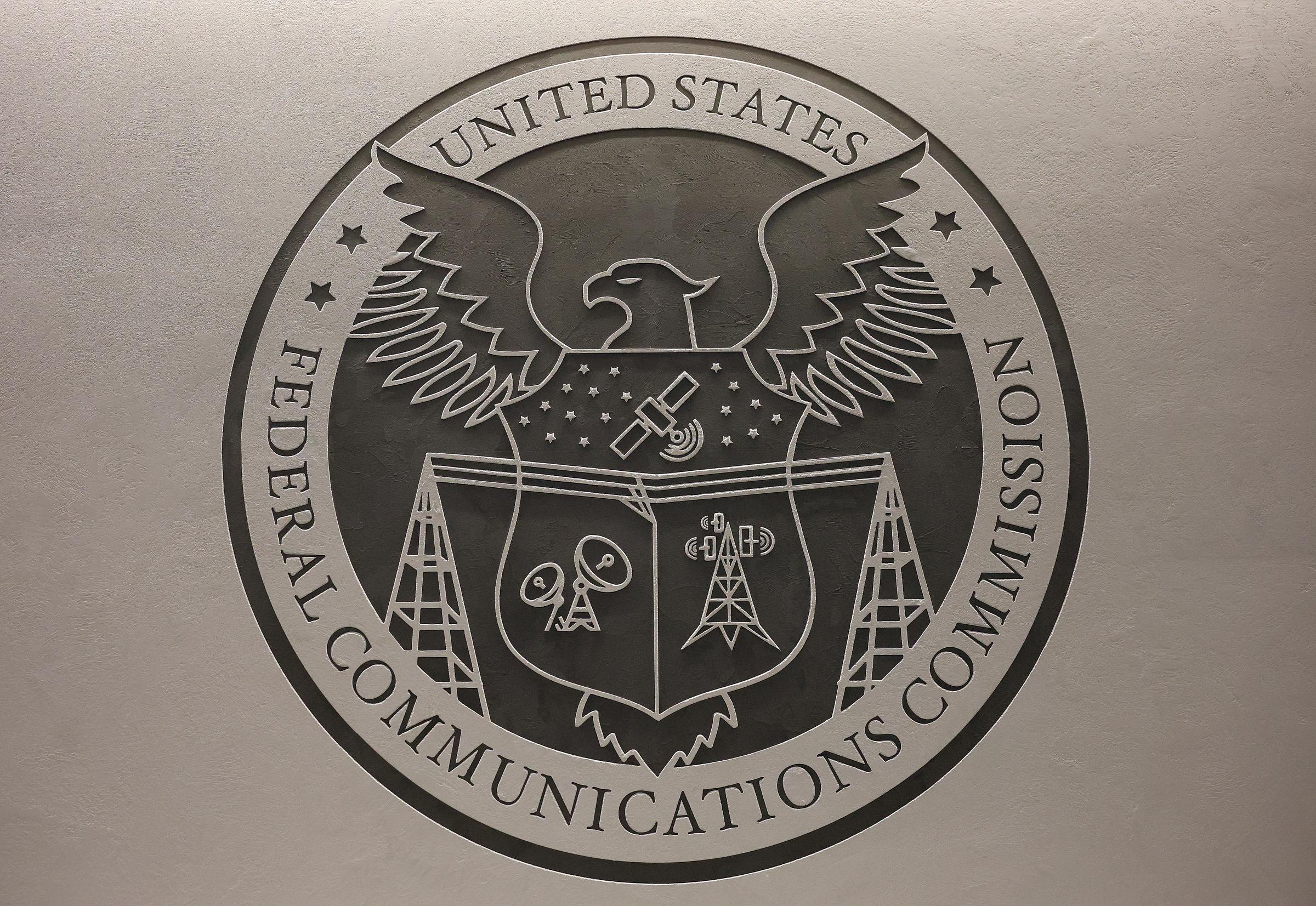 The seal for the Federal Communications Commission (FCC) is seen in the Commission's briefing room during a meeting at FCC headquarters on February 18, 2026 in Washington, DC | Source: Getty Images