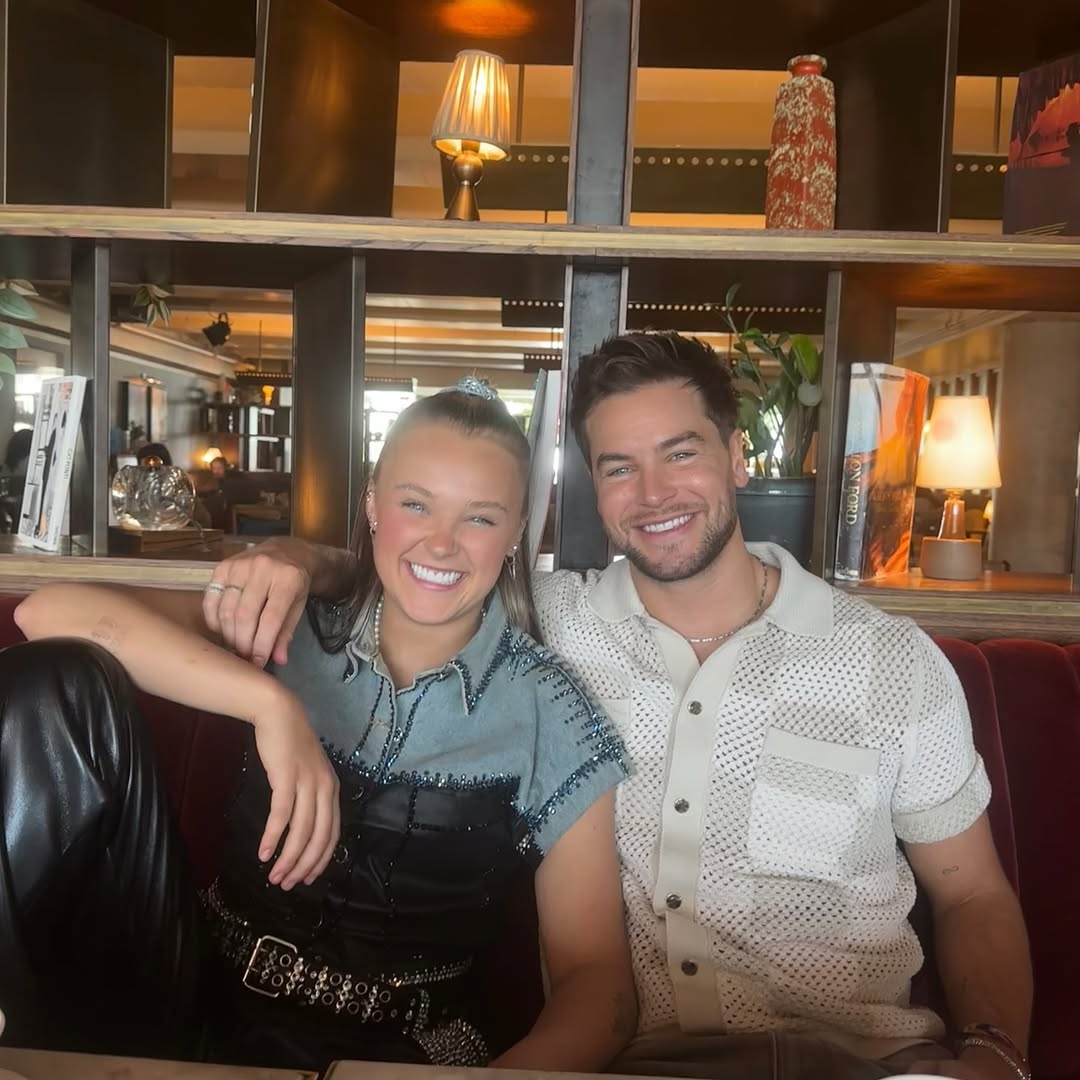 JoJo Siwa and Chris Hughes posing together at a restaurant from a post dated April 30, 2025 | Source: Instagram/chrishughesofficial