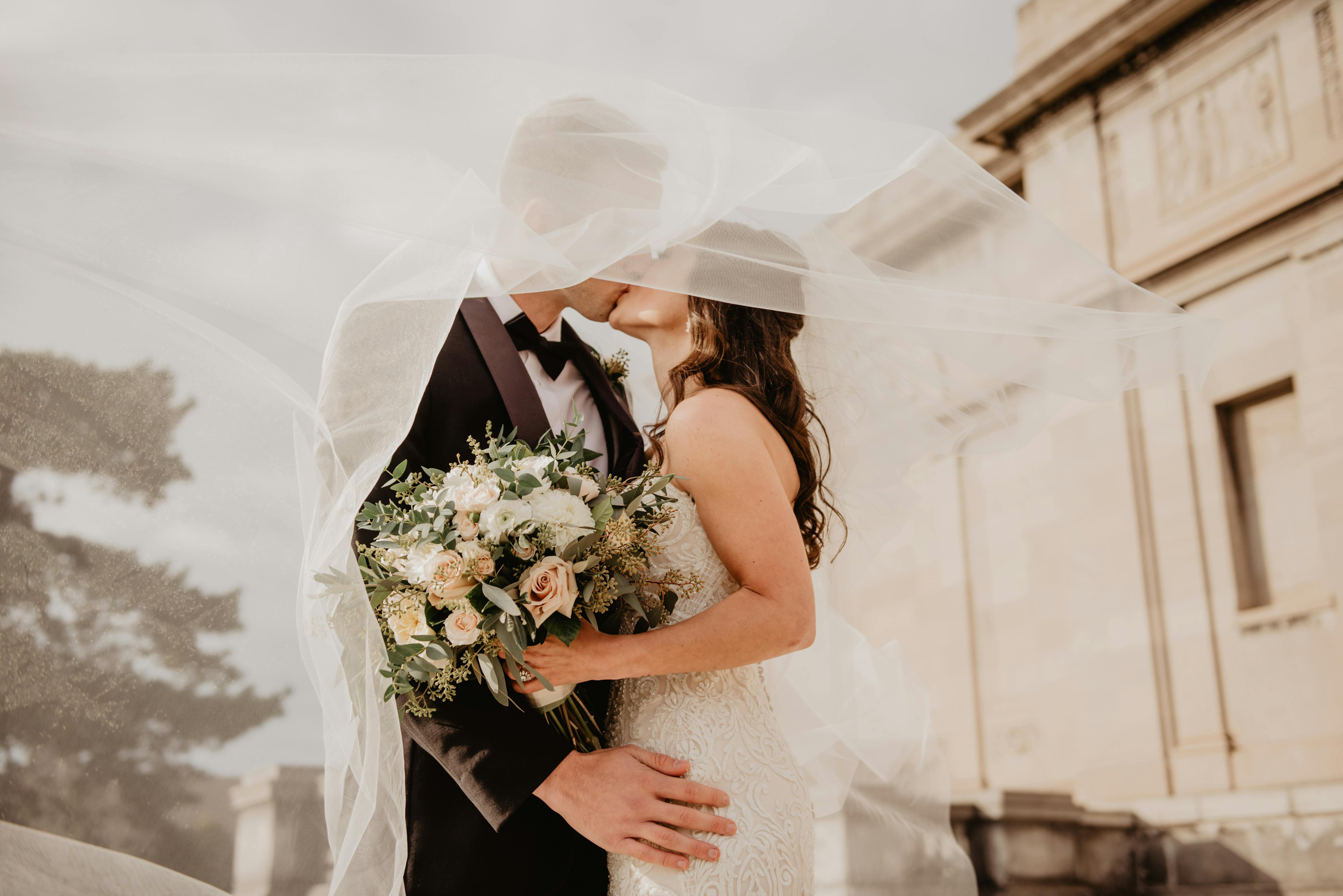 A man and woman kiss during their wedding ceremony | Source: Pexels