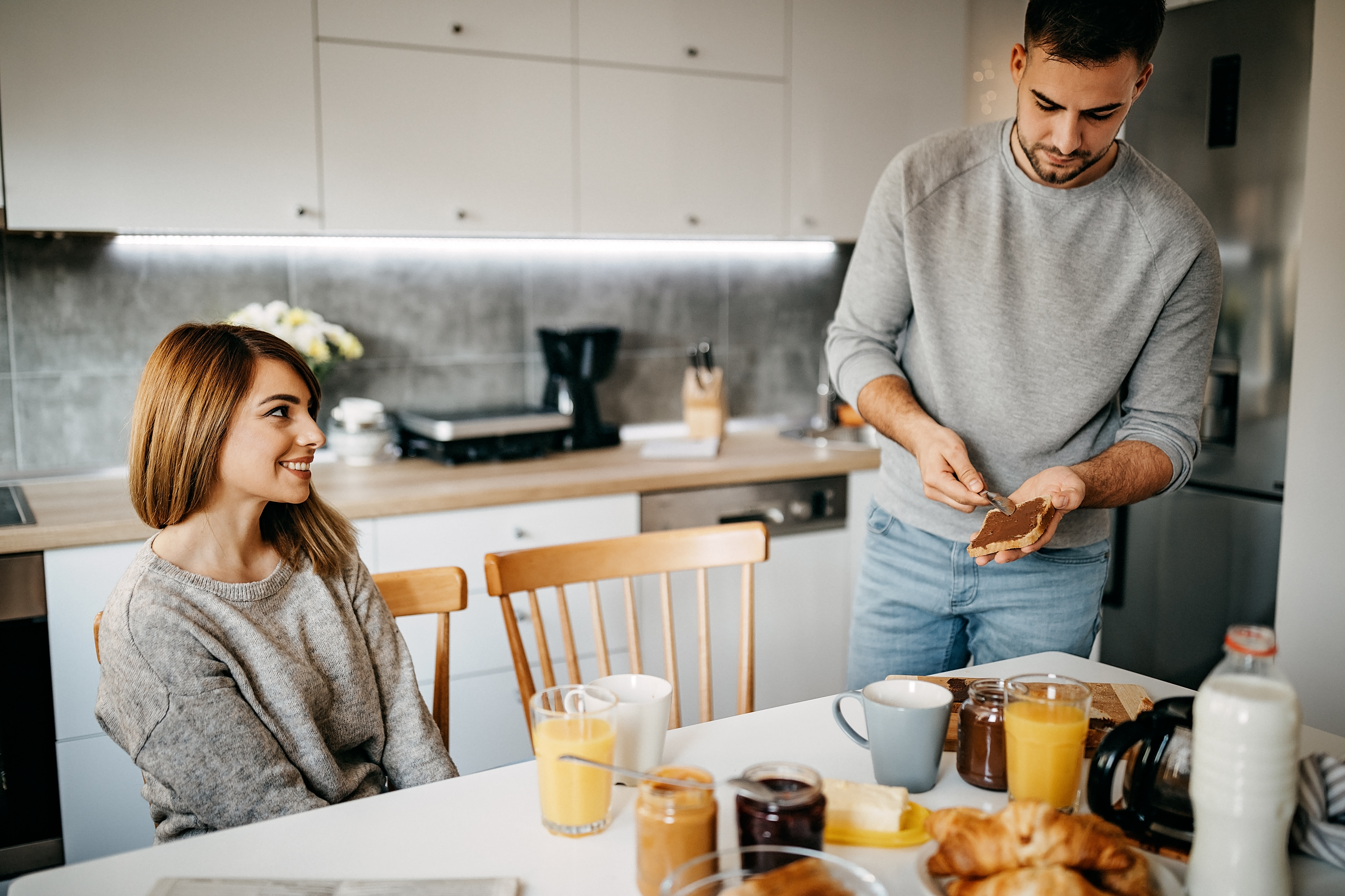 Couple making breakfast in kitchen, full of emotions | Source: Getty Images