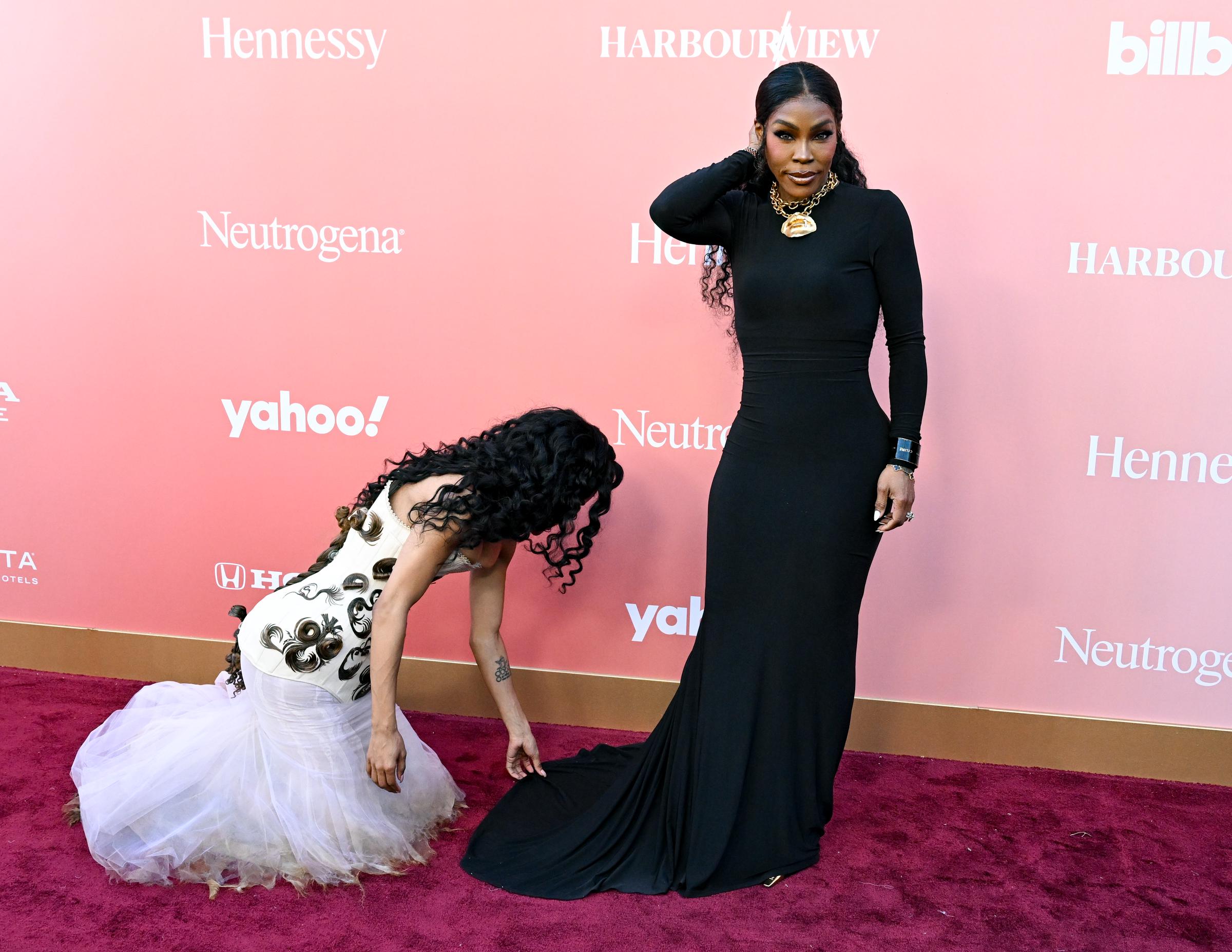 Teyana Taylor crouches to adjust Nikki's gown | Source: Getty Images