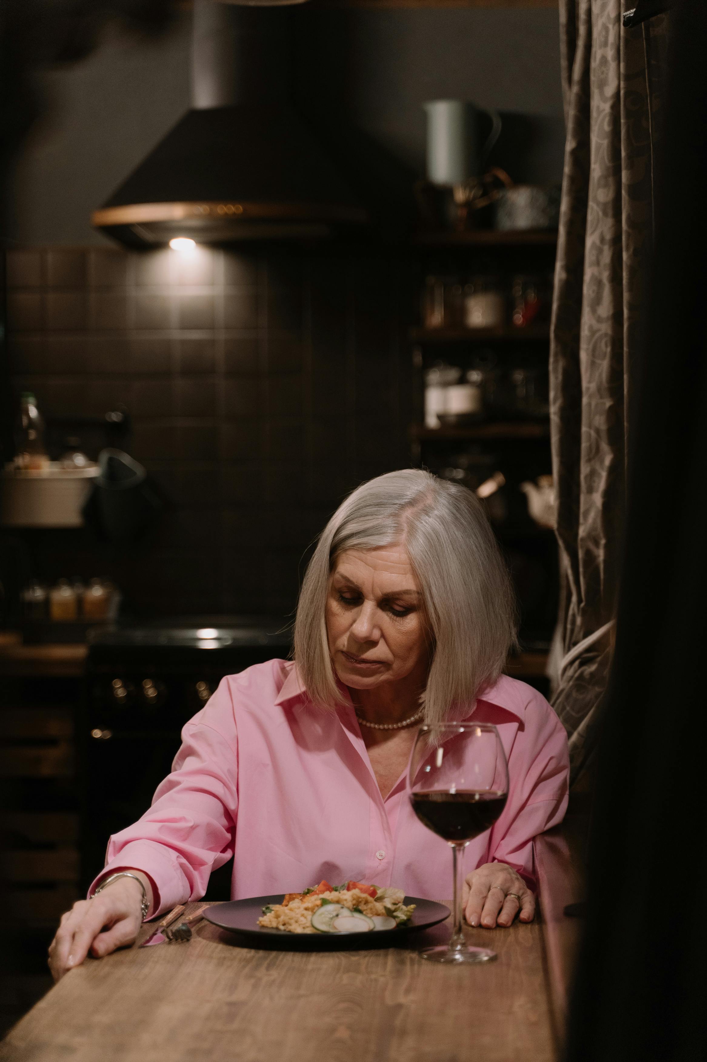 An upset woman at a dinner table | Source: Pexels