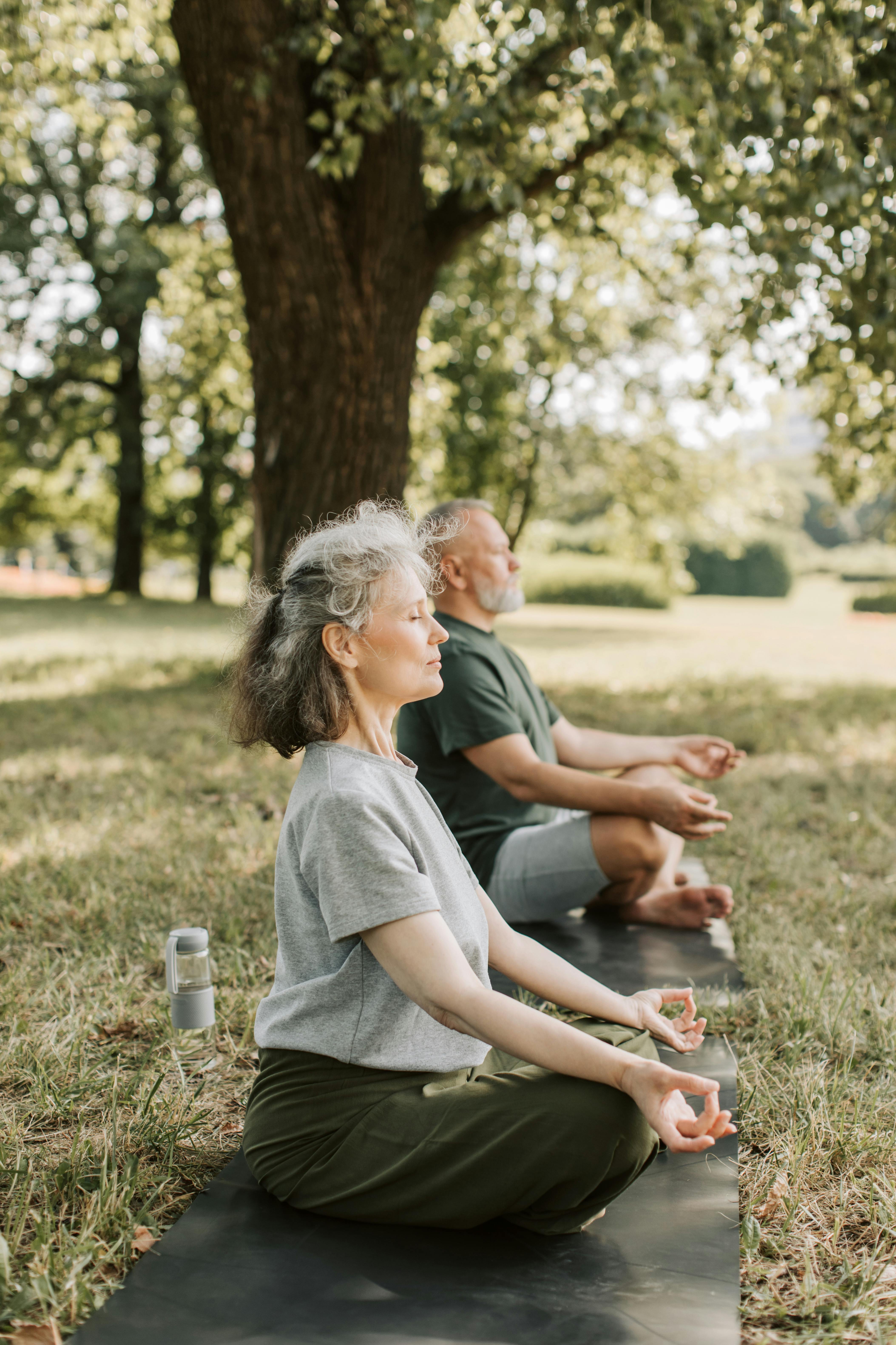 A couple does yoga at the park | Source: Pexels