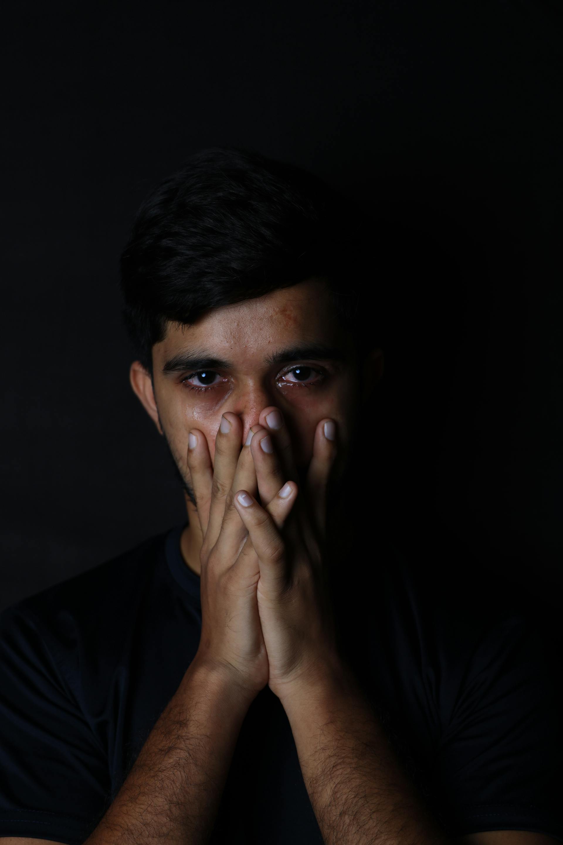 A broken man covering his mouth with his hands | Source: Pexels