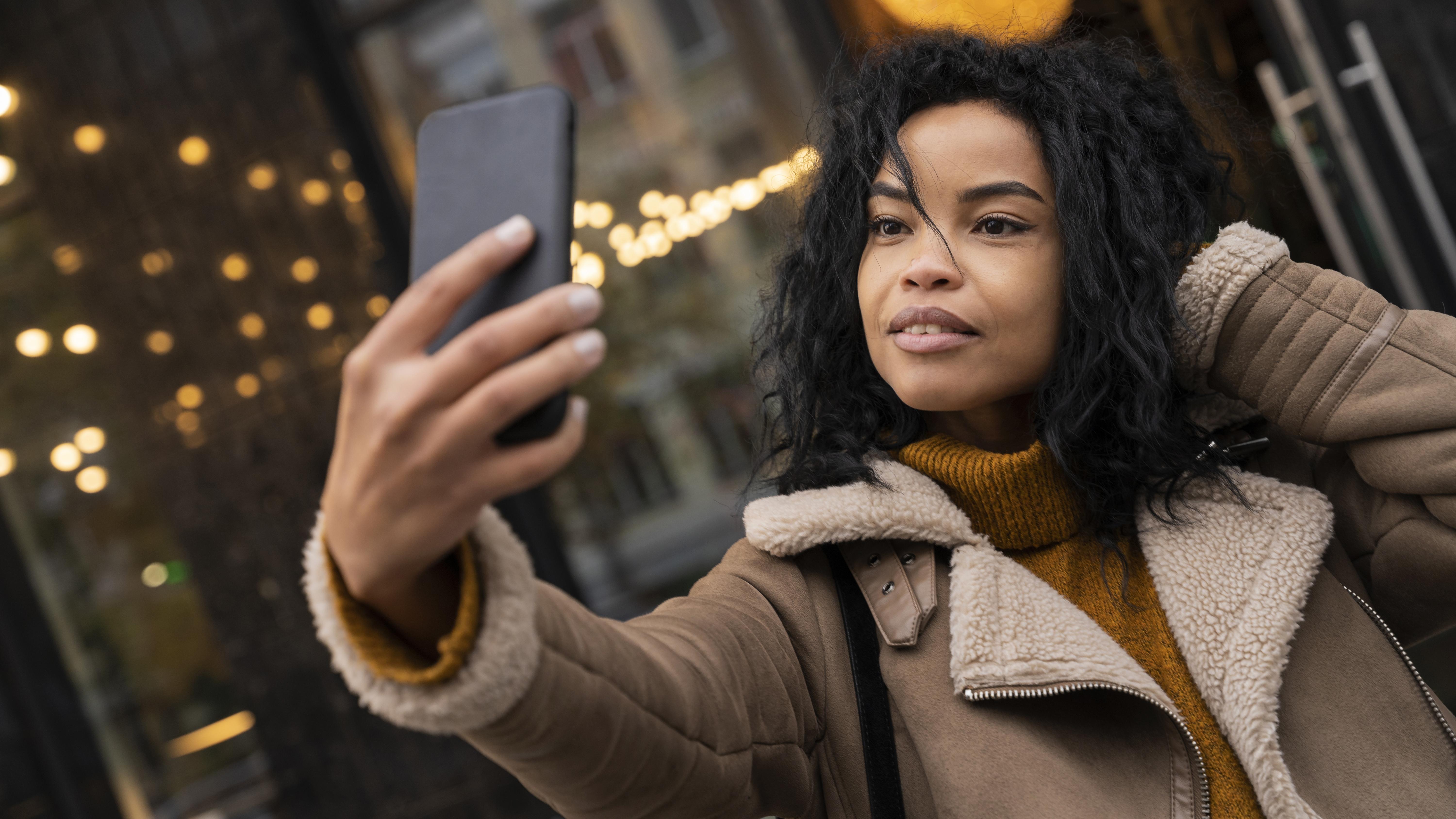 A woman taking a selfie with her phone | Source: Freepik