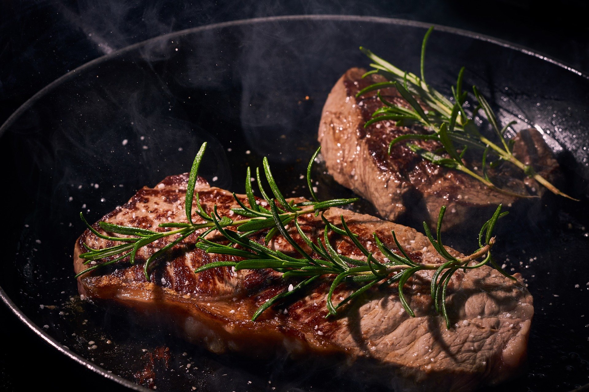 Sprigs of rosemary used to flavor some steak cuts in a pan | Photo: Pixabay/Felix Wolf