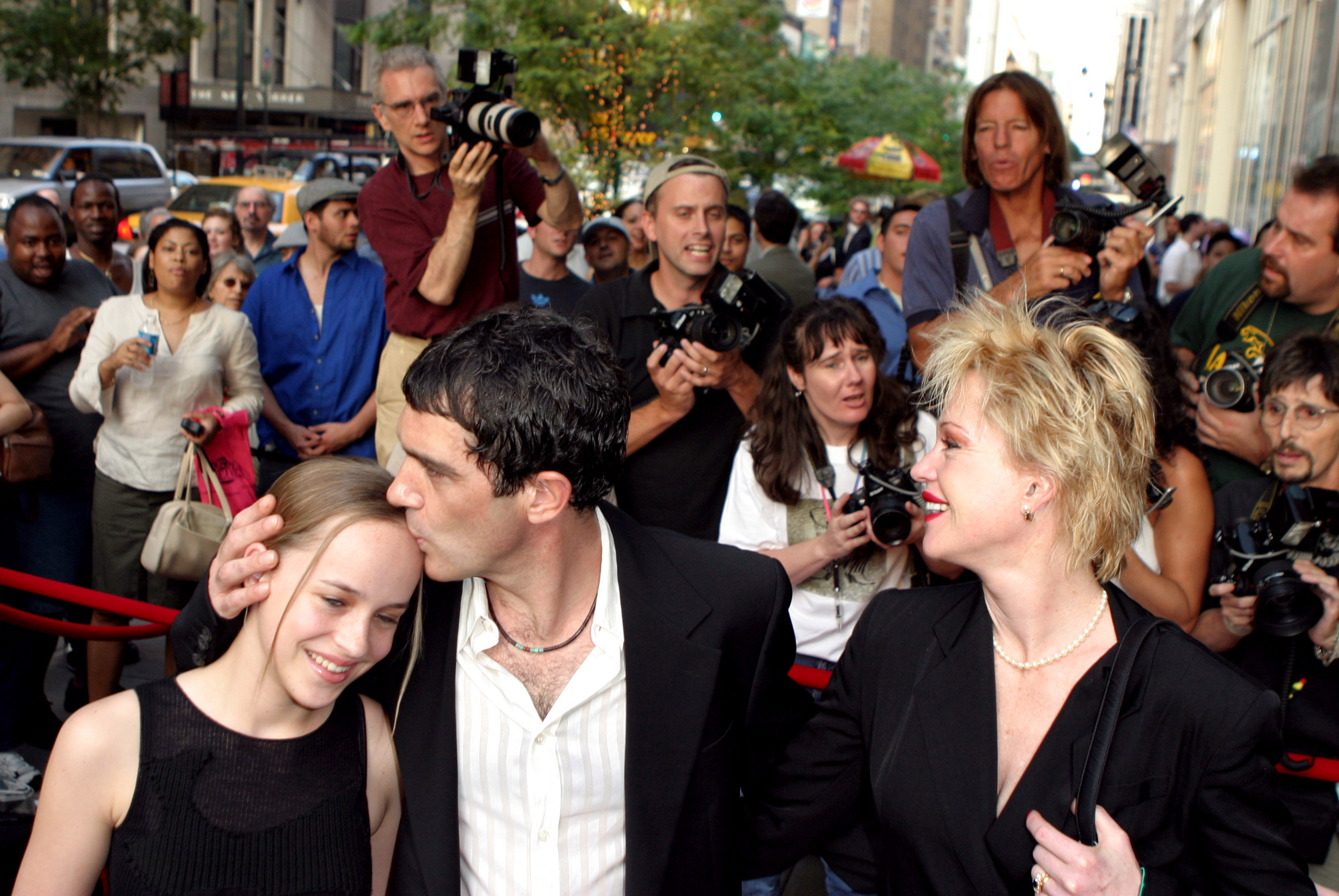 Antonio Banderas kisses Dakota Johnson on the head as Melanie Griffith smiles beside them at the premiere of "And Starring Pancho Villa As Himself" in New York on August 18, 2003. | Source: Getty Images