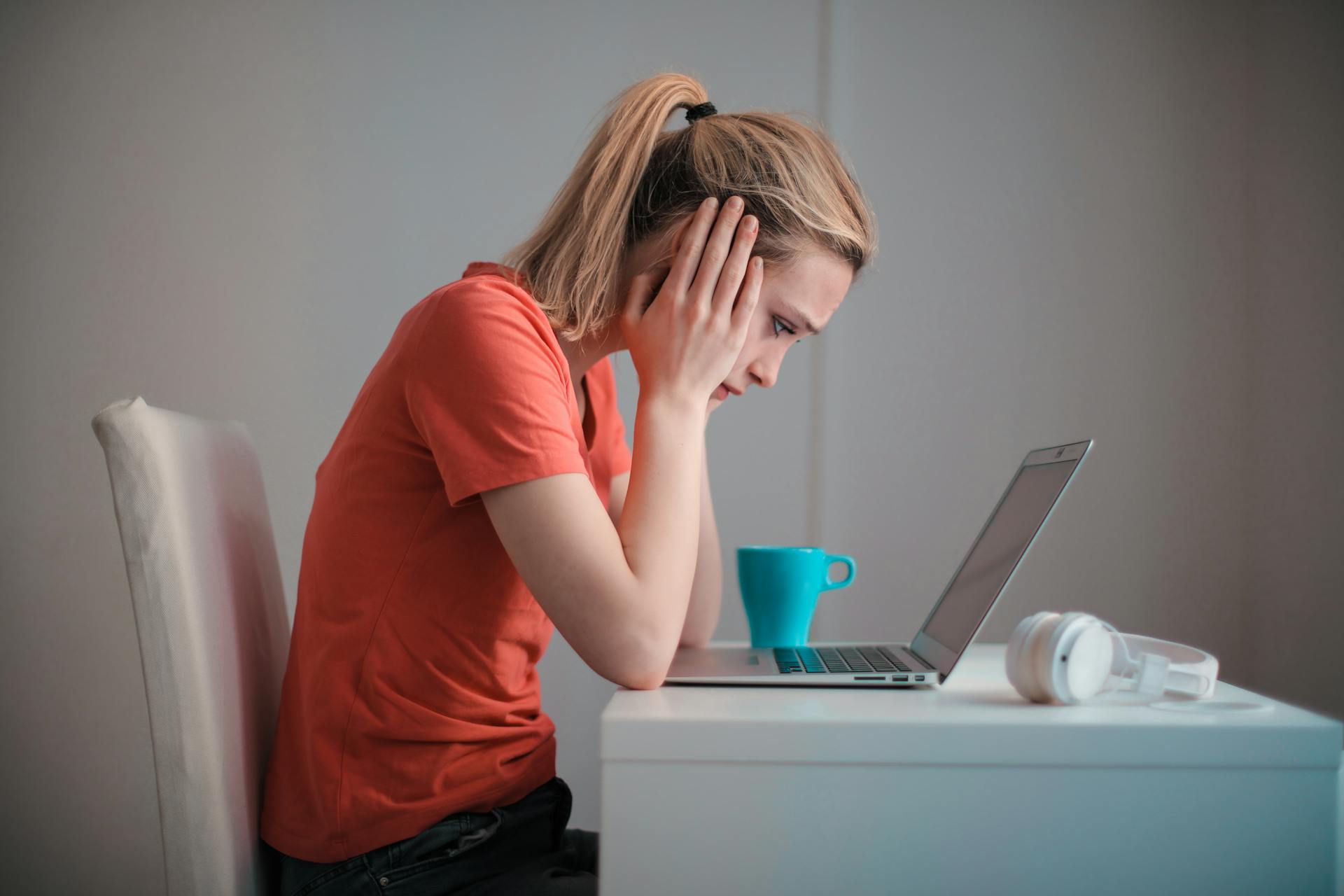 A woman looking at her laptop and holding her head | Source: Pexels