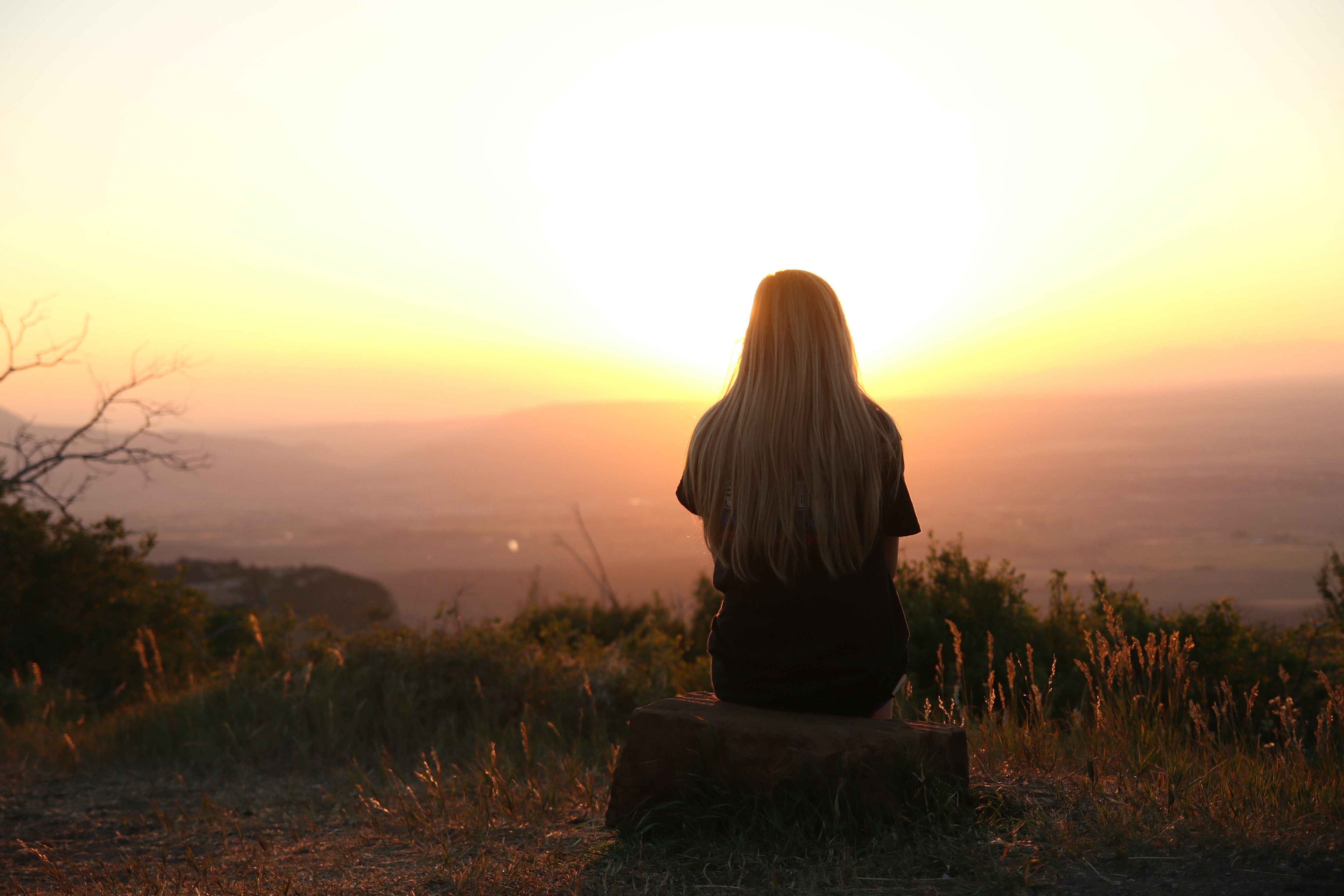 A woman looking into the sunset. | Photo: Pexels