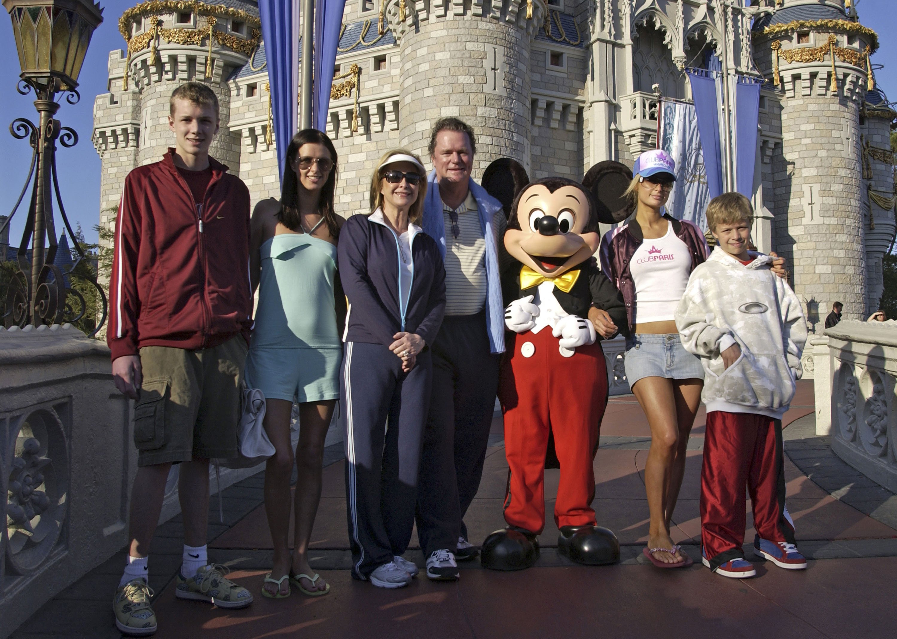 (L-R) Barron Hilton, Nicky Hilton, parents Kathy Hilton and Rick Hilton, Paris Hilton and Conrad Hilton pose with Mickey Mouse at Walt Disney World Resort on February 19, 2005 in Lake Buena Vista, Florida. | Source: Getty Images