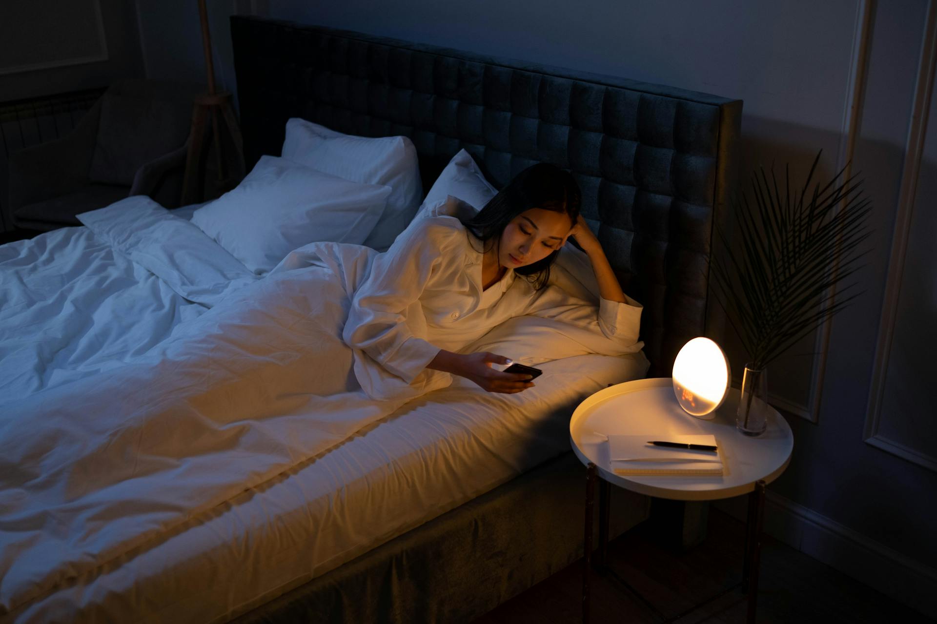 A woman using her phone in her bed | Source: Pexels